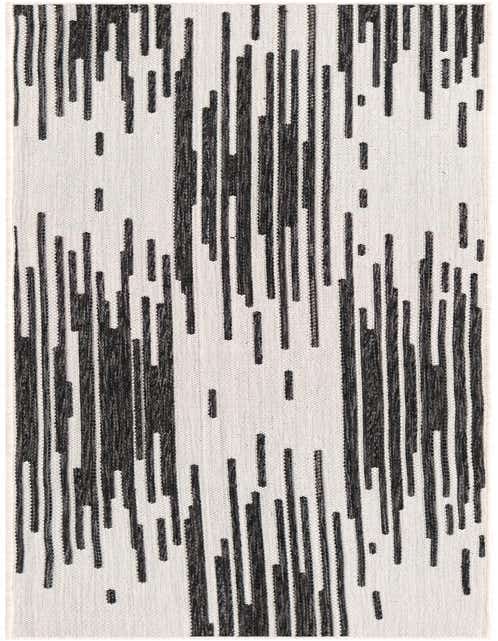 A black and white modern runner rug with a dynamic vertical stripe pattern, ideal for a hallway or patio.