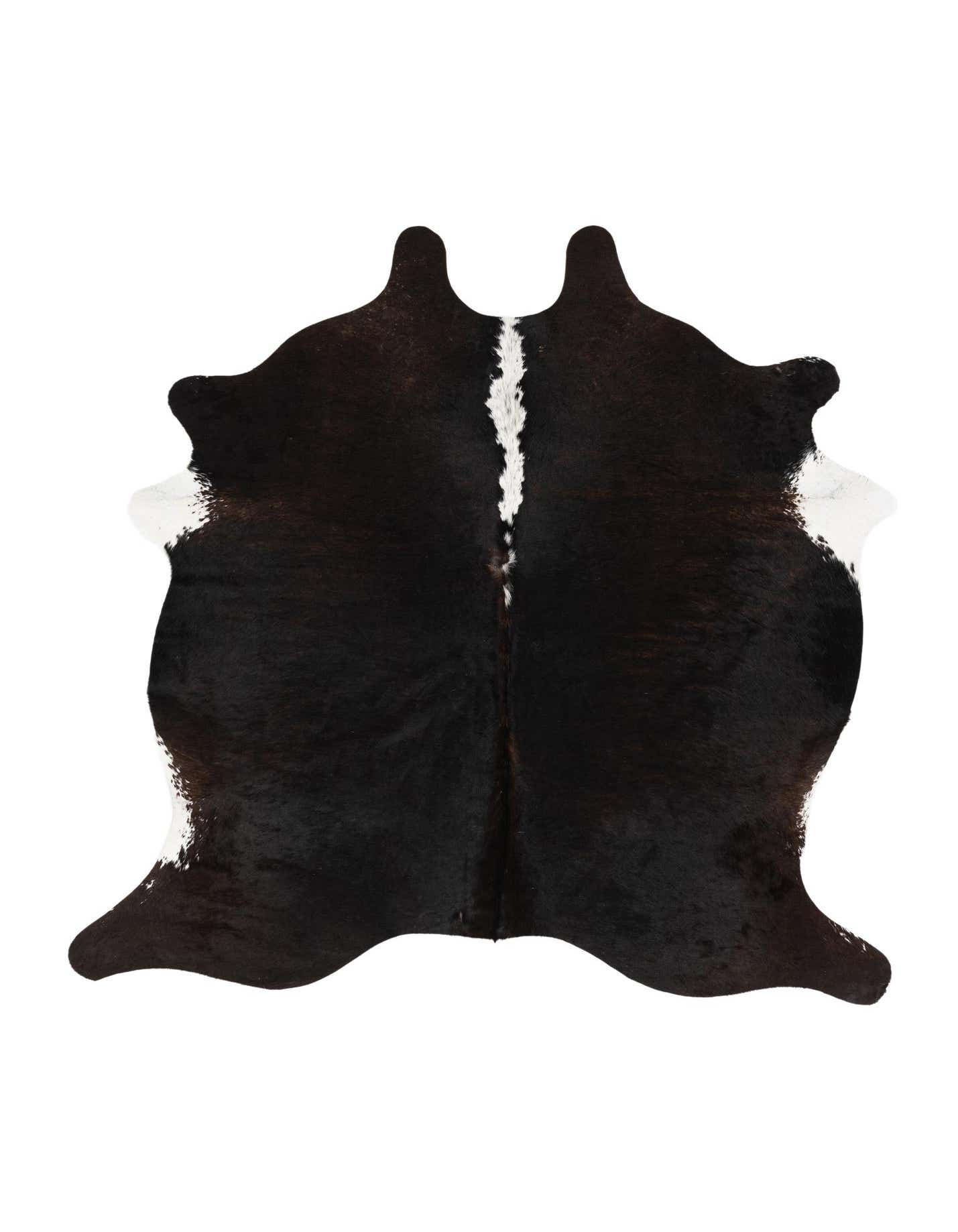 A black and white cowhide rug with an irregular, organic shape, featuring a prominent white stripe down the center.