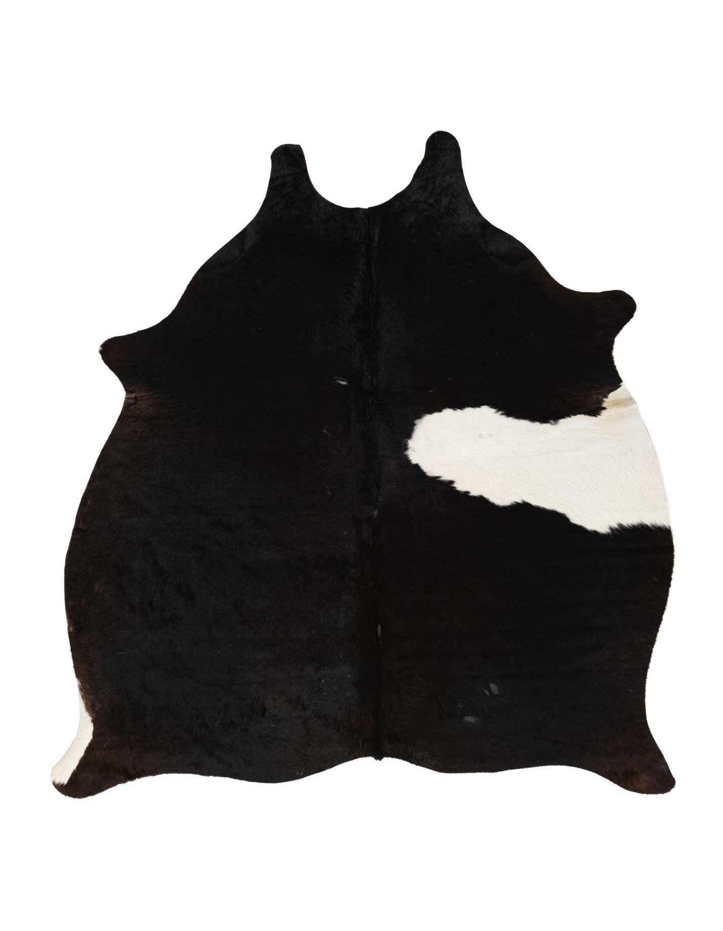 A black and white cowhide rug with an organic, irregular shape, featuring a large white patch on one side.