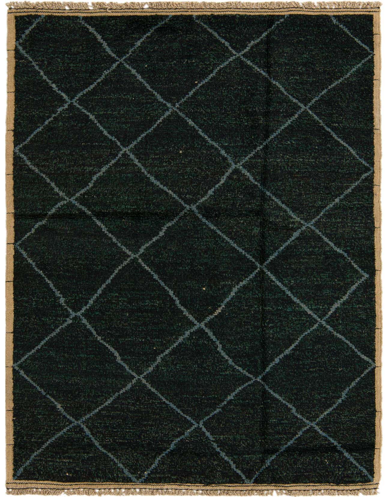 A 5x8 rectangular black shag rug with a subtle green undertone and a light blue tribal diamond pattern, featuring natural fringed edges.