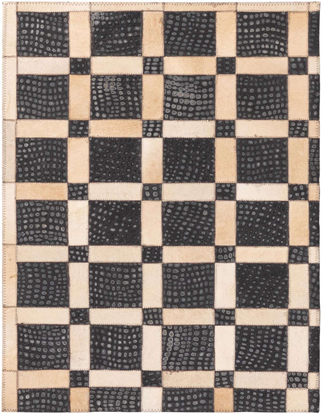 A 2x3 rectangular Cowhide rug featuring a modern checkerboard pattern of black textured leather squares and light beige cowhide rectangles, with visible stitching.
