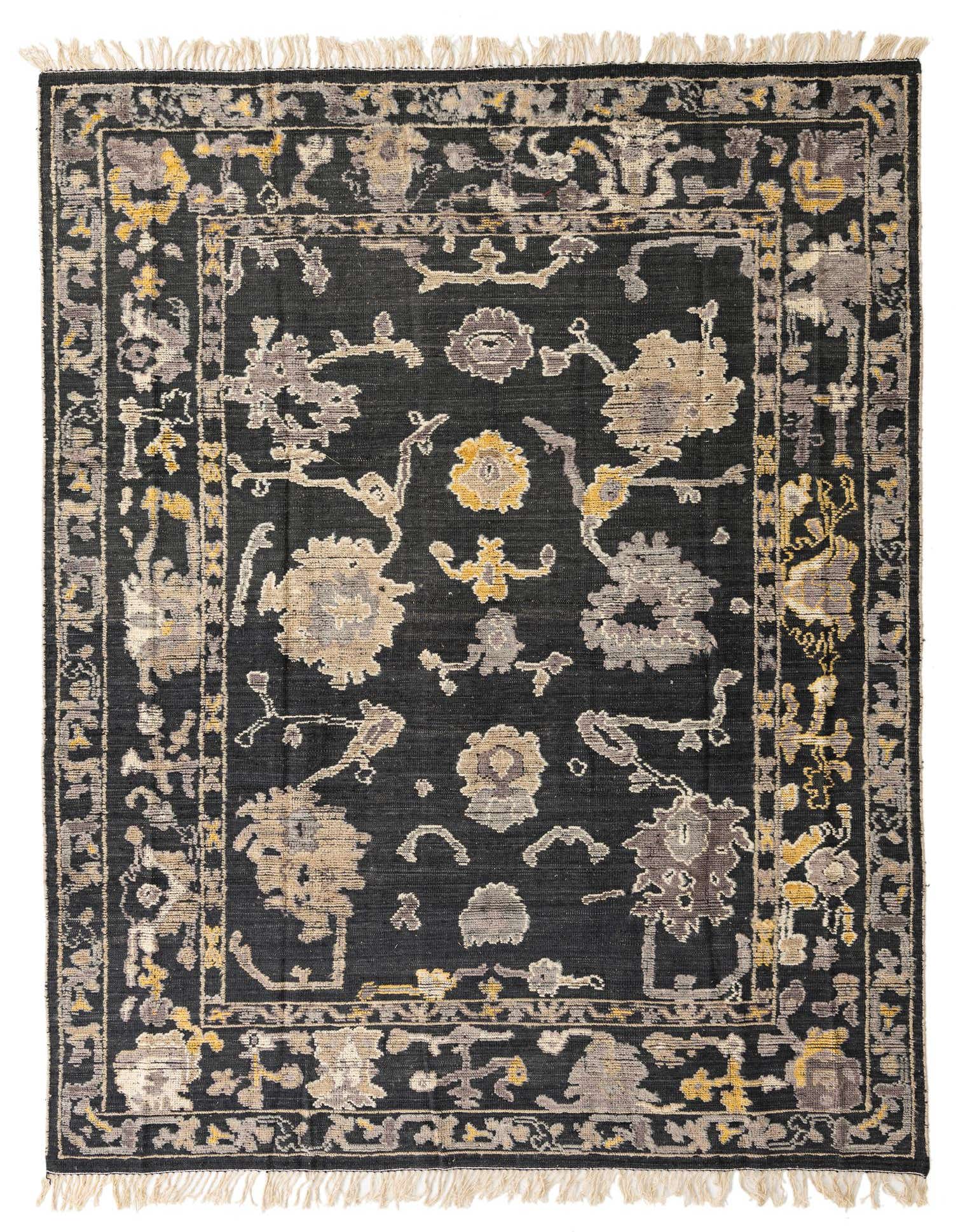 A rectangular 8x10 Darya Collection wool rug in black with abstract floral patterns in grey, beige, and yellow, featuring a high pile and fringe.