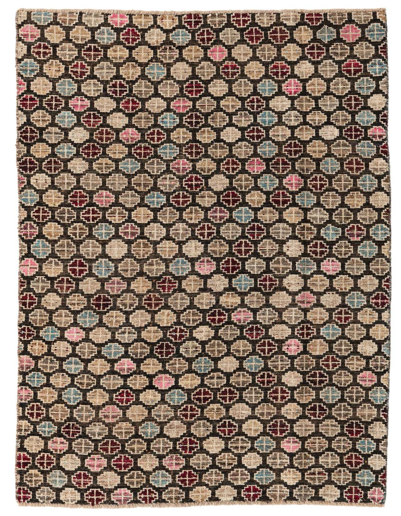 A 5x8 rectangular black wool rug with a modern abstract pattern of multicolored geometric shapes in pink, blue, and brown tones.