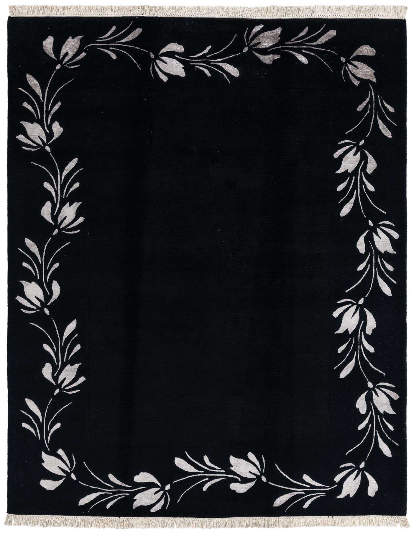 A 5x8 rectangular black wool area rug with a modern oriental style, featuring a light floral border pattern and short fringe.