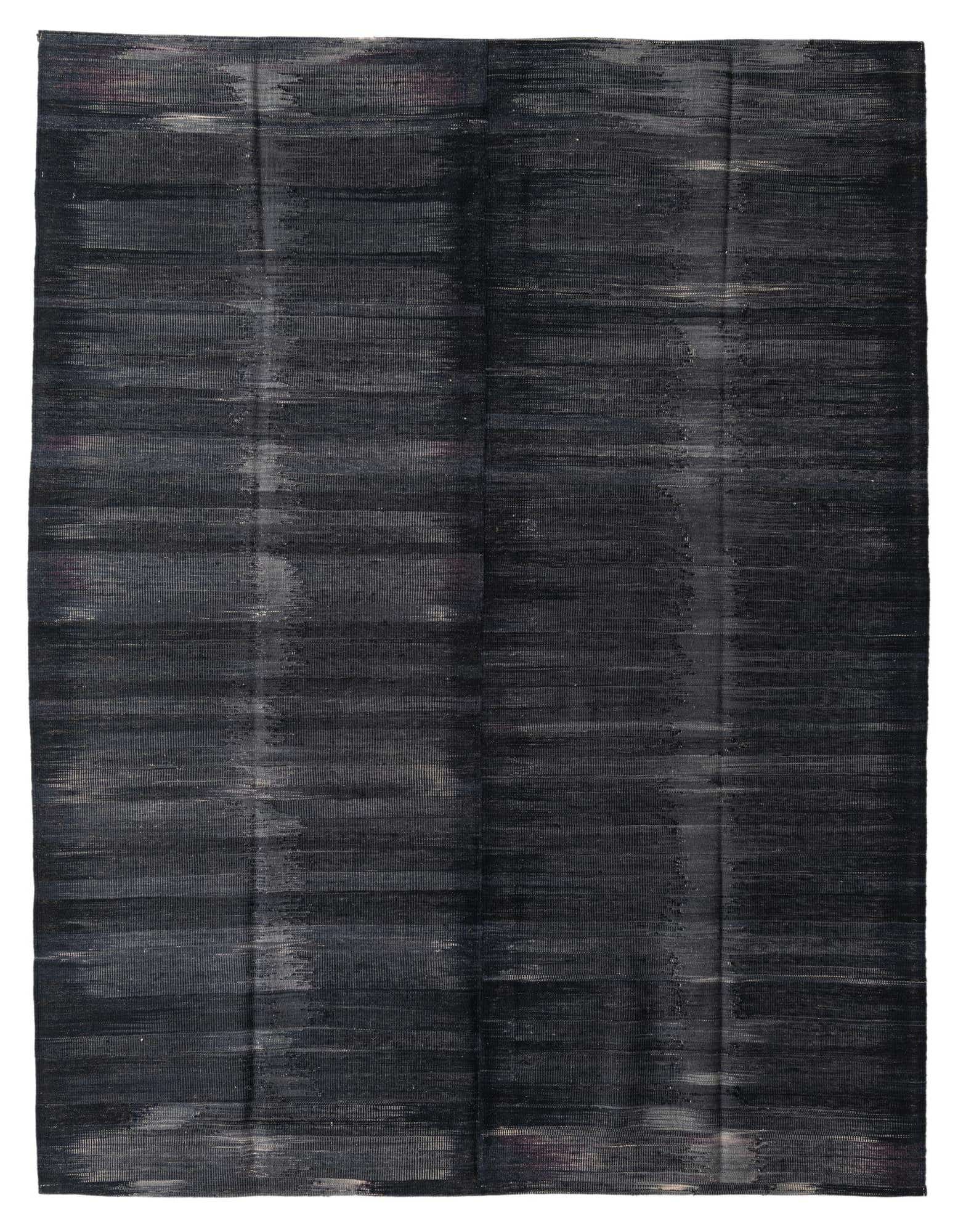A 7x10 rectangular black tribal flatweave wool rug with subtle horizontal variations, suitable for a modern living room.