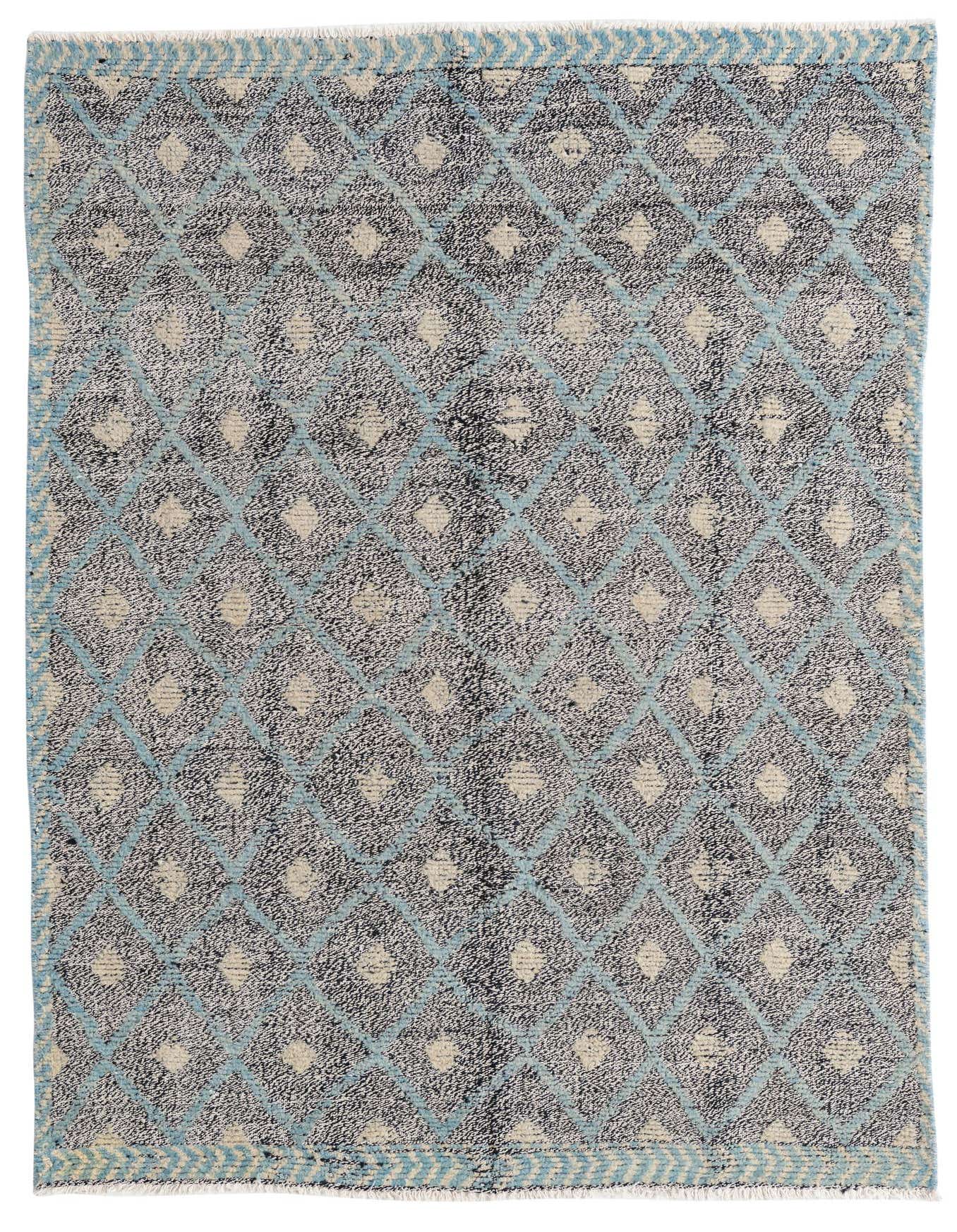 A 5x7 rectangular black wool rug with a modern Southwestern diamond pattern in light blue and cream, featuring a thin pile.