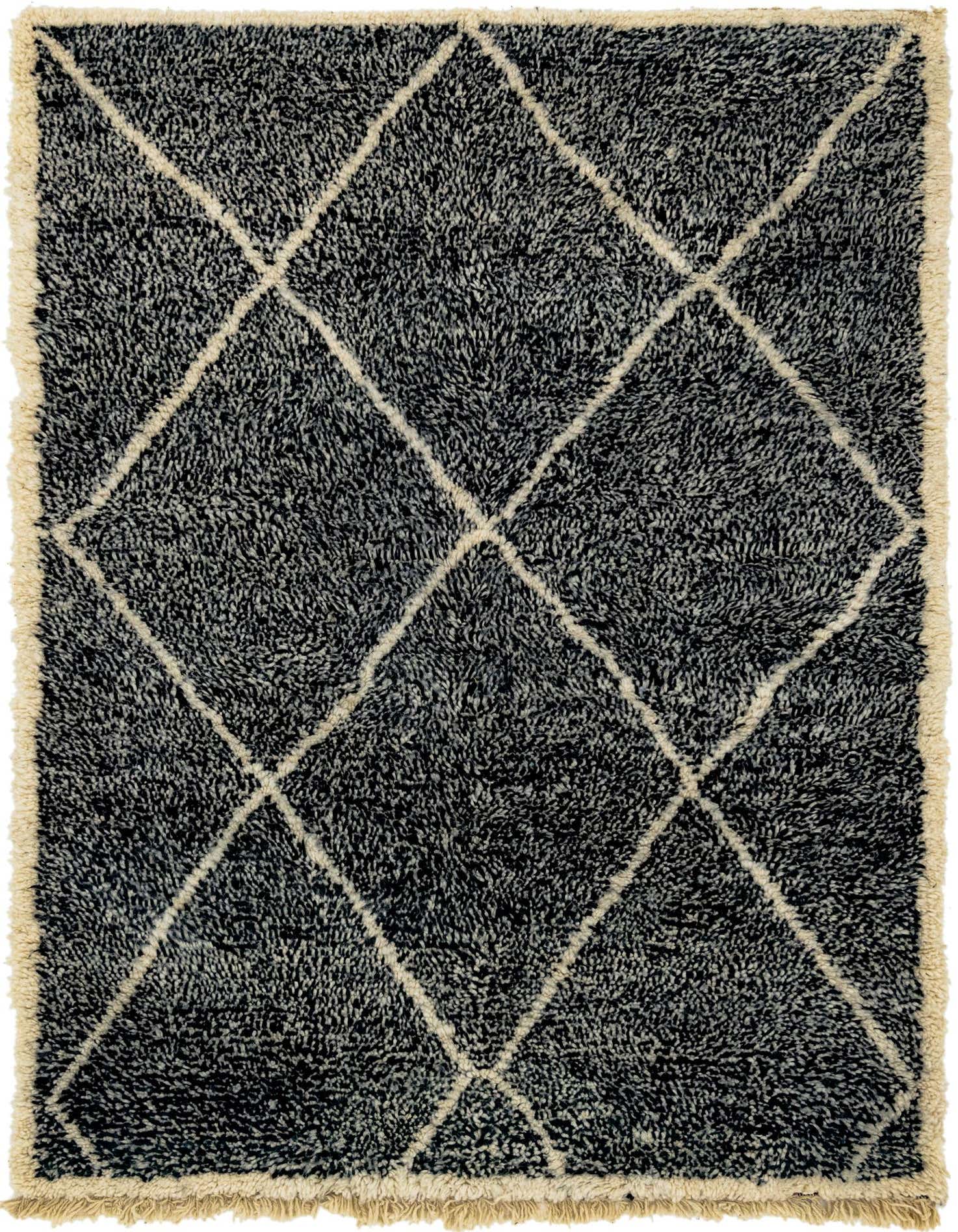A 6x9 rectangular black shag rug with a cream tribal diamond pattern and fringed edges, perfect for a modern living room.
