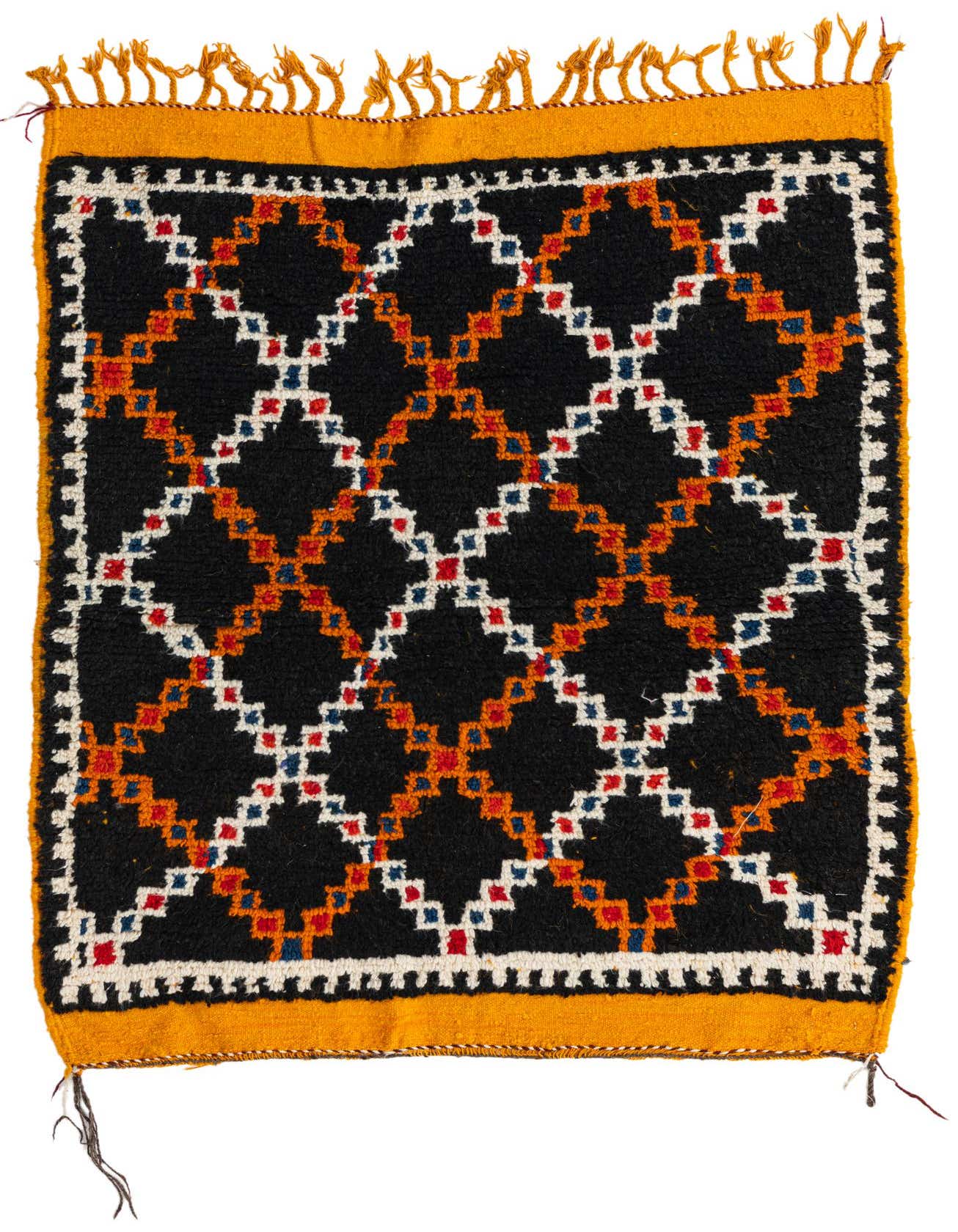 A 3x4 rectangular black Moroccan shag rug with a tribal geometric pattern in orange, red, blue, and white, featuring yellow fringe.