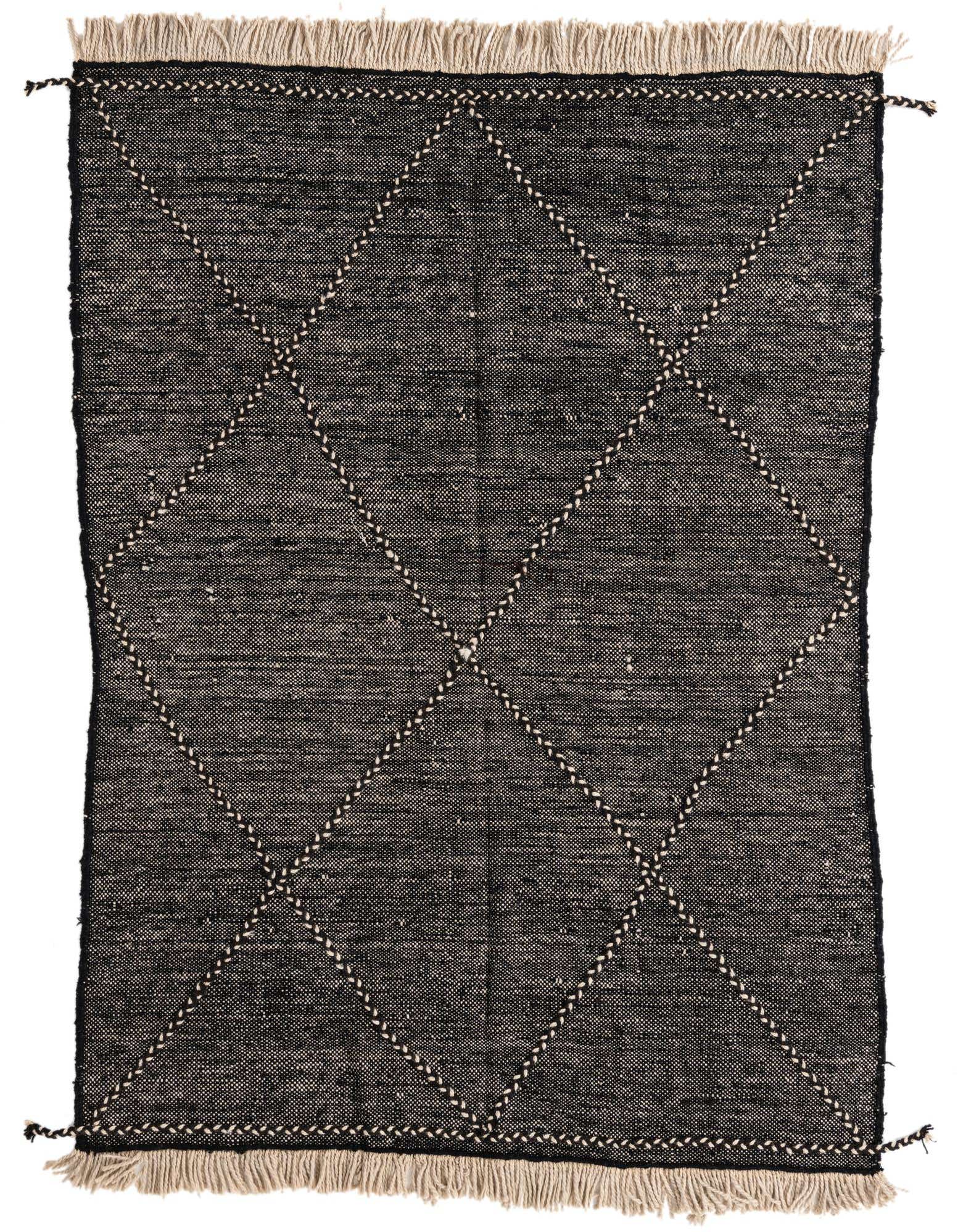 A 5x8 rectangular black wool shag rug with a white tribal diamond pattern and fringed edges.