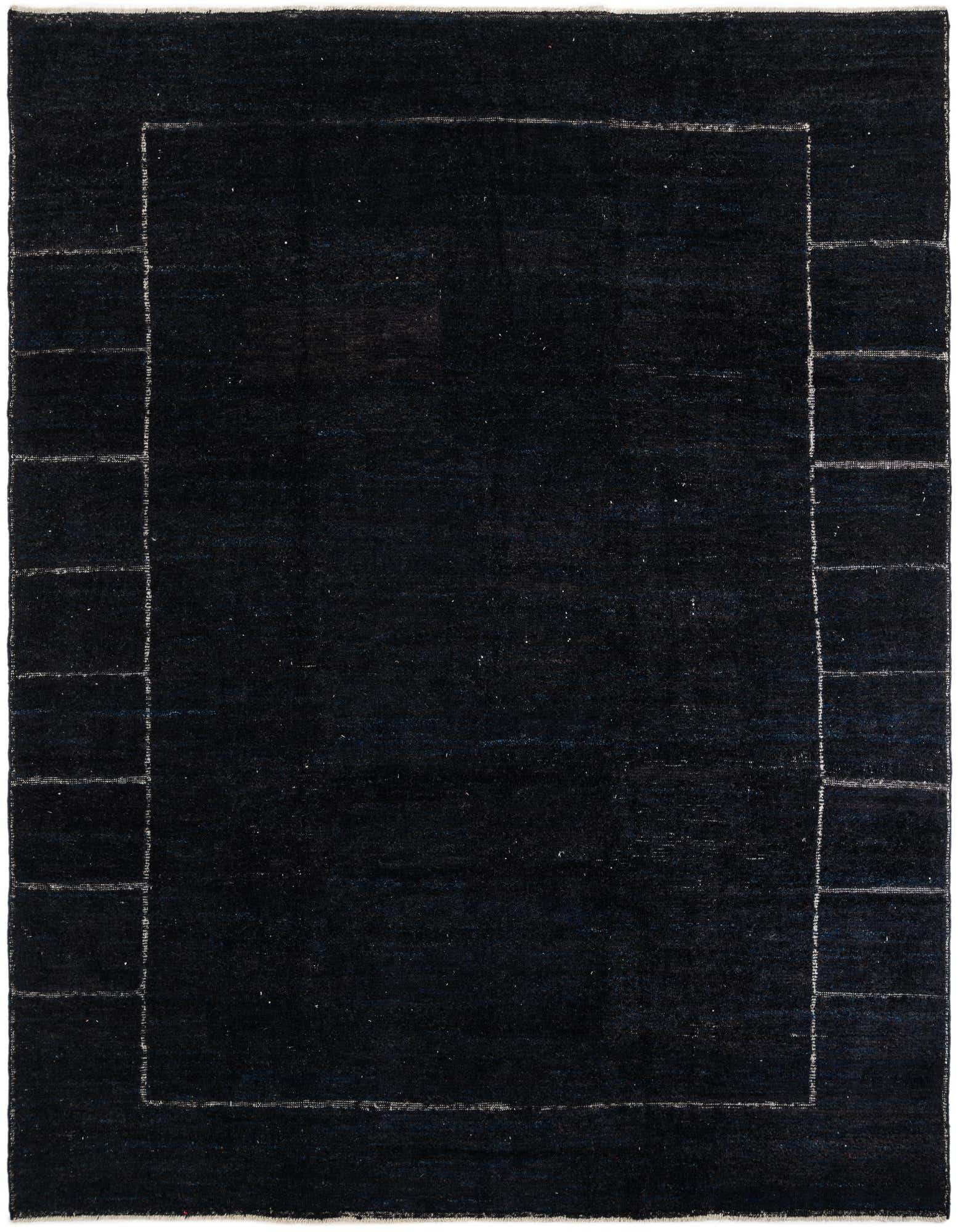 A 9x12 rectangular black wool shag rug with a subtle light-colored tribal border, suitable for a living room.