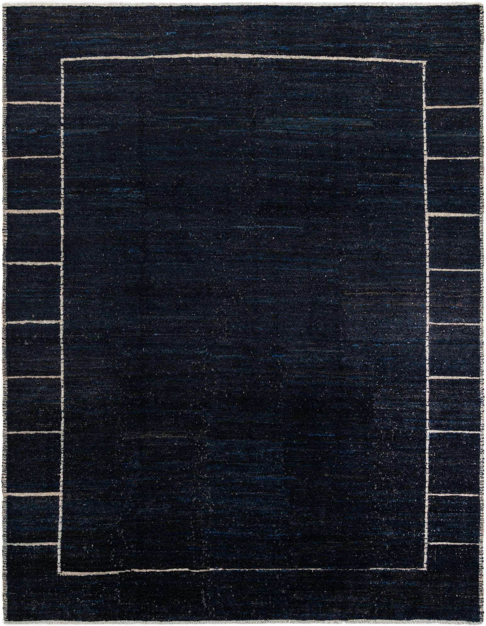 A 9x11 rectangular black shag rug with a thin white border and tribal block pattern on the sides.