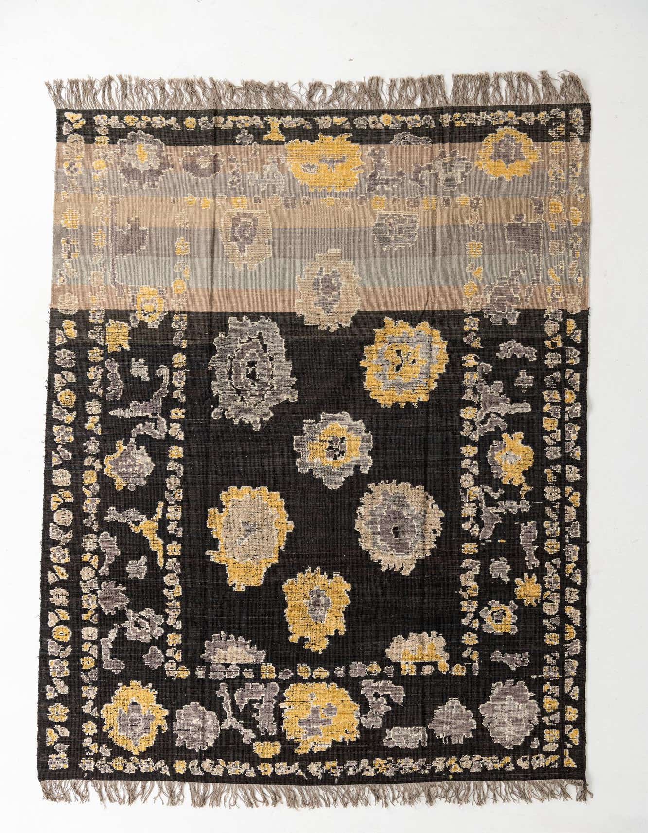 A 10x13 rectangular Oushak rug with a modern floral pattern in black, grey, and yellow, featuring a striped top border and fringe.
