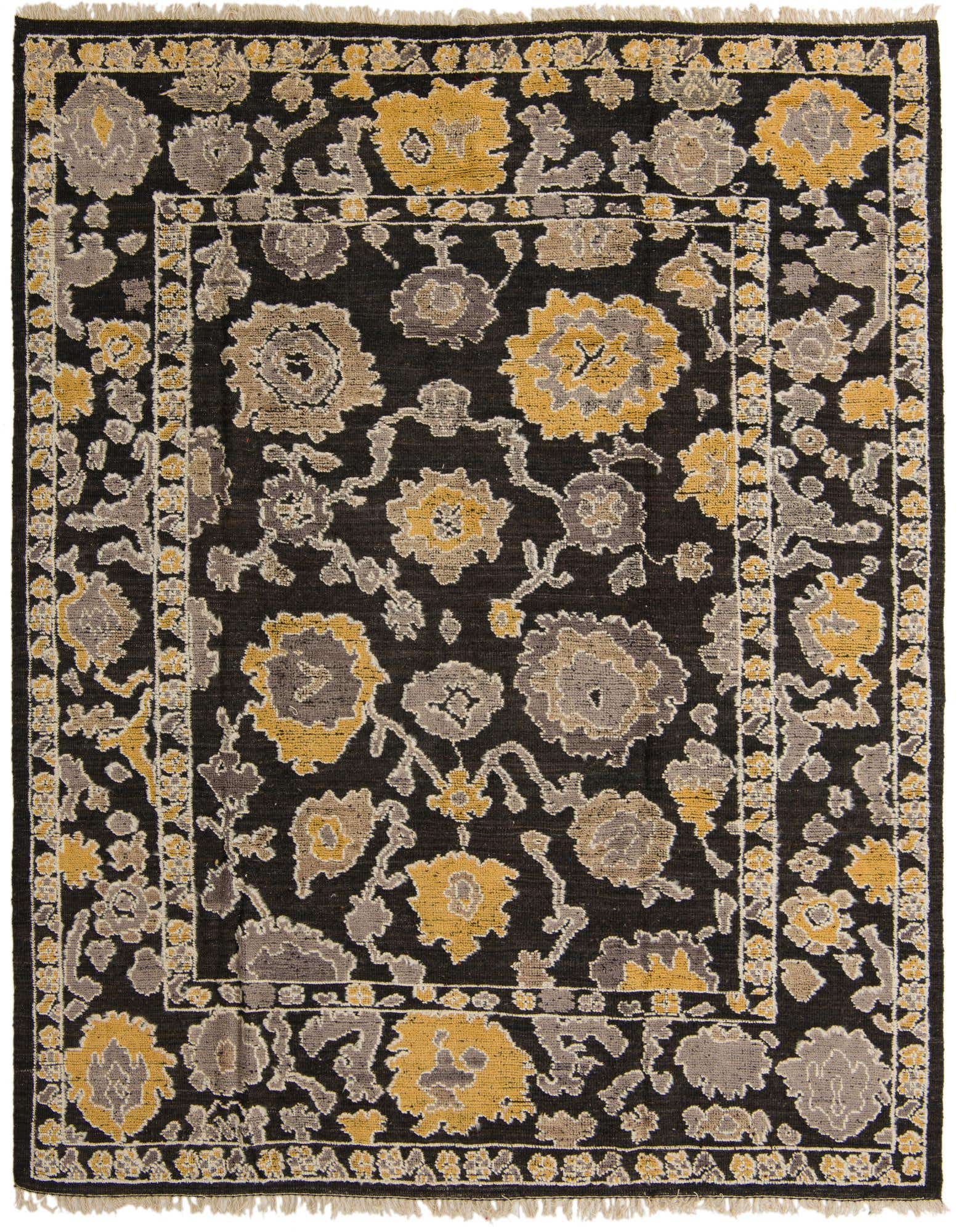 An 8x10 rectangular black wool rug with a modern abstract floral pattern in gold and gray, featuring a textured pile and fringe.