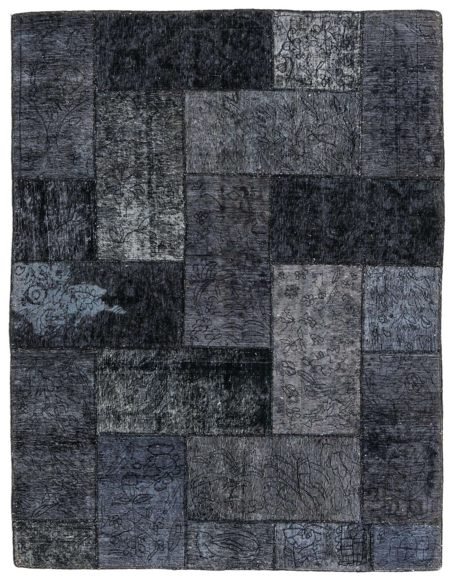 A 5x8 rectangular black patchwork rug with varied distressed Persian and abstract patterns, suitable for a living room.