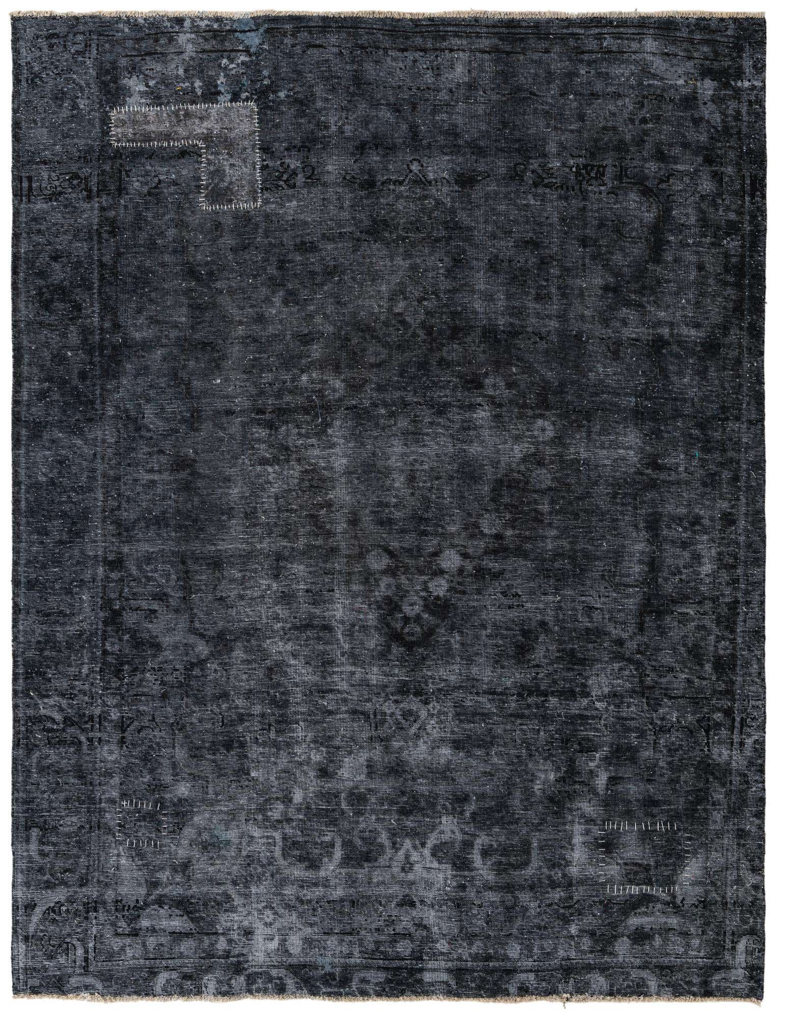 A 7x10 rectangular black vintage Persian rug with a faded medallion pattern and visible handmade patches.