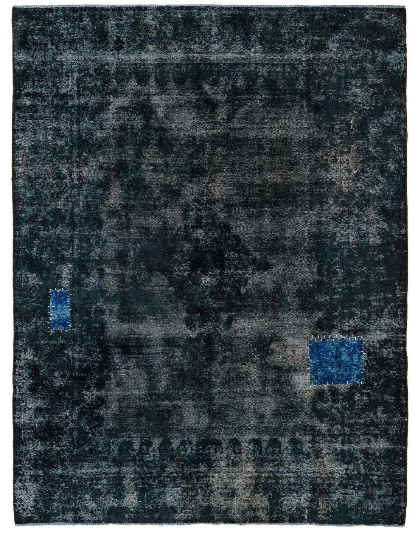 A 7x10 rectangular black Persian rug with a faded vintage pattern and two bright blue patches.
