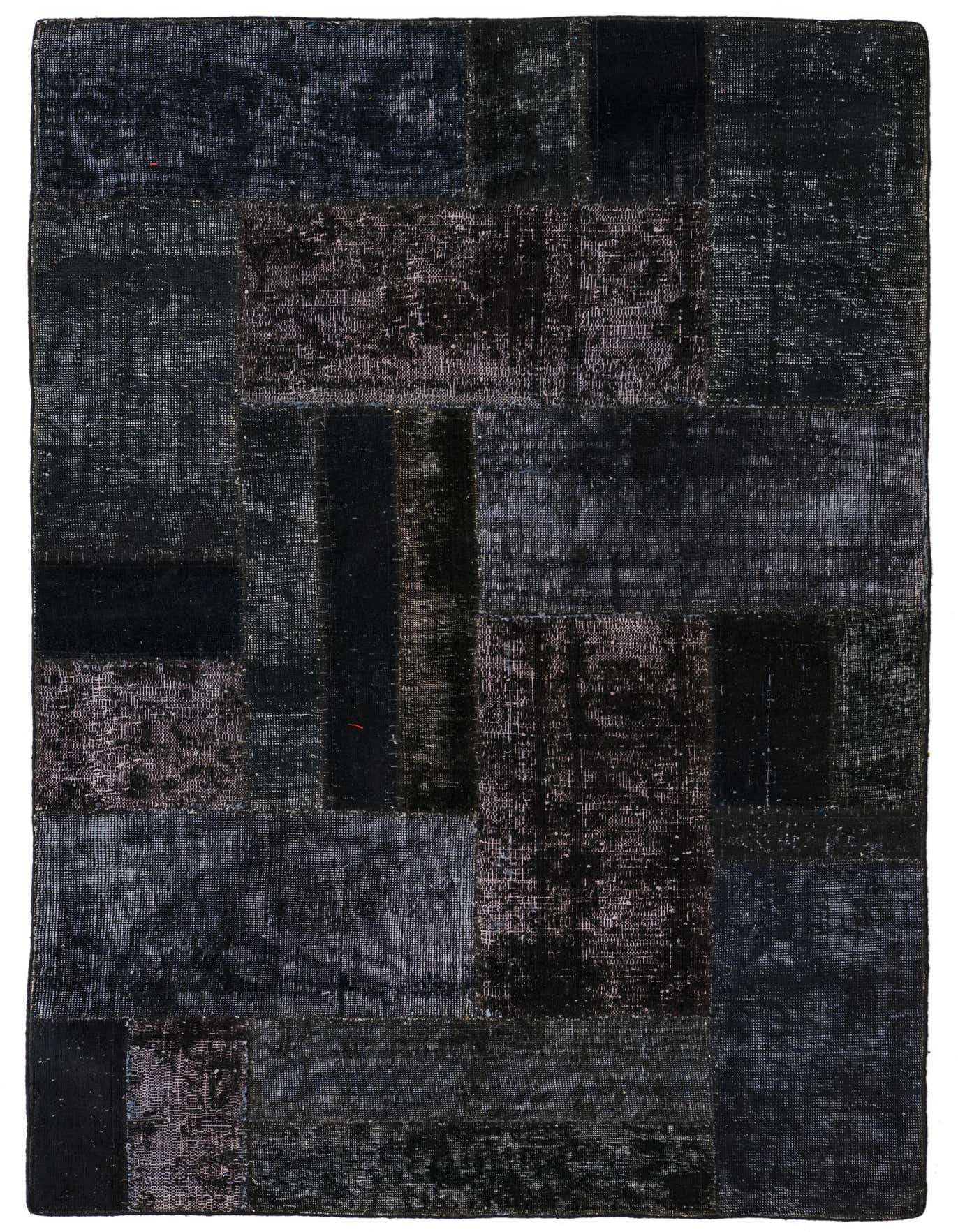 A 4x6 rectangular black patchwork rug with varied distressed patterns, suitable for a living room.