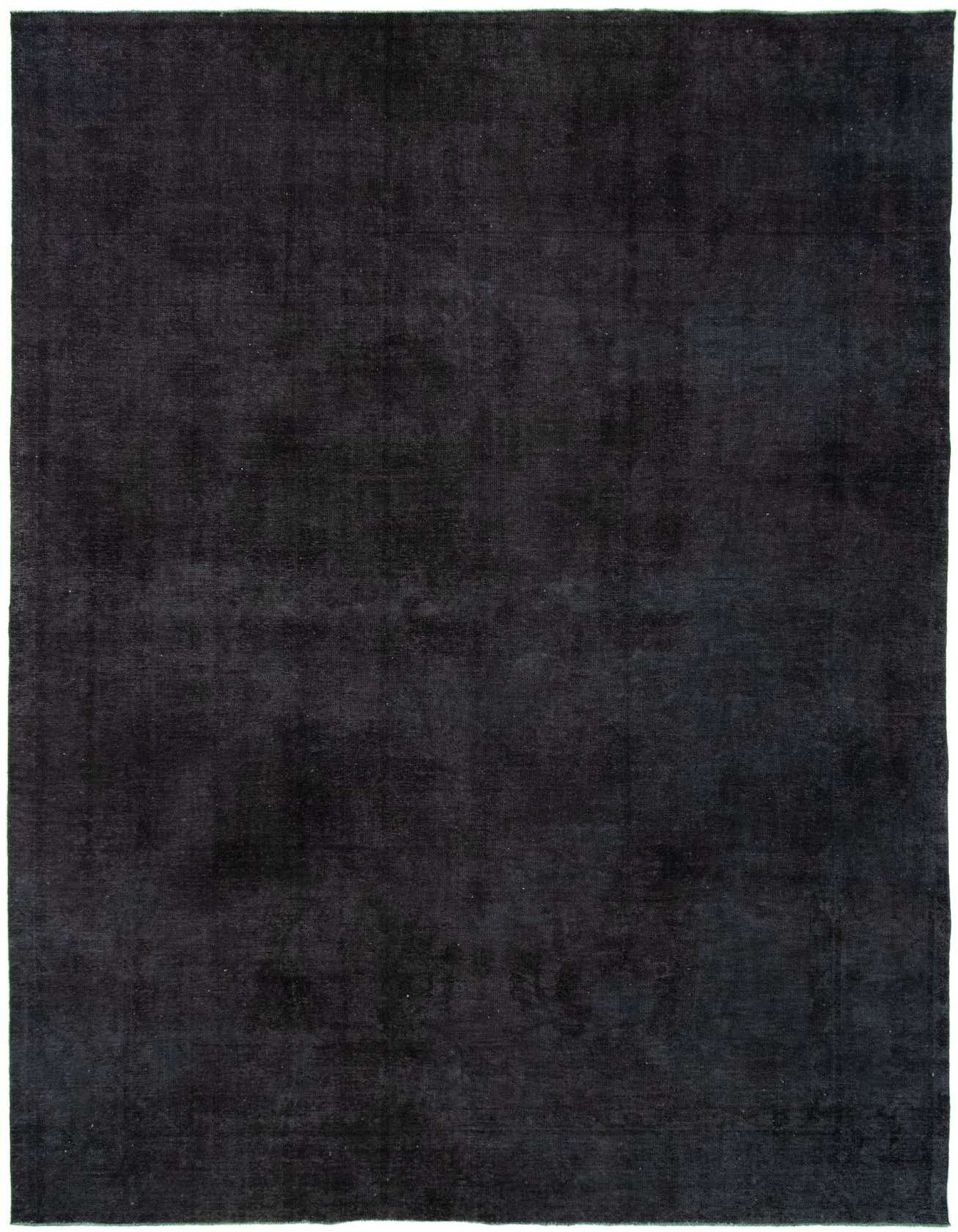 A large 10x16 rectangular black wool area rug with a subtle, distressed Persian pattern, suitable for an indoor living space.