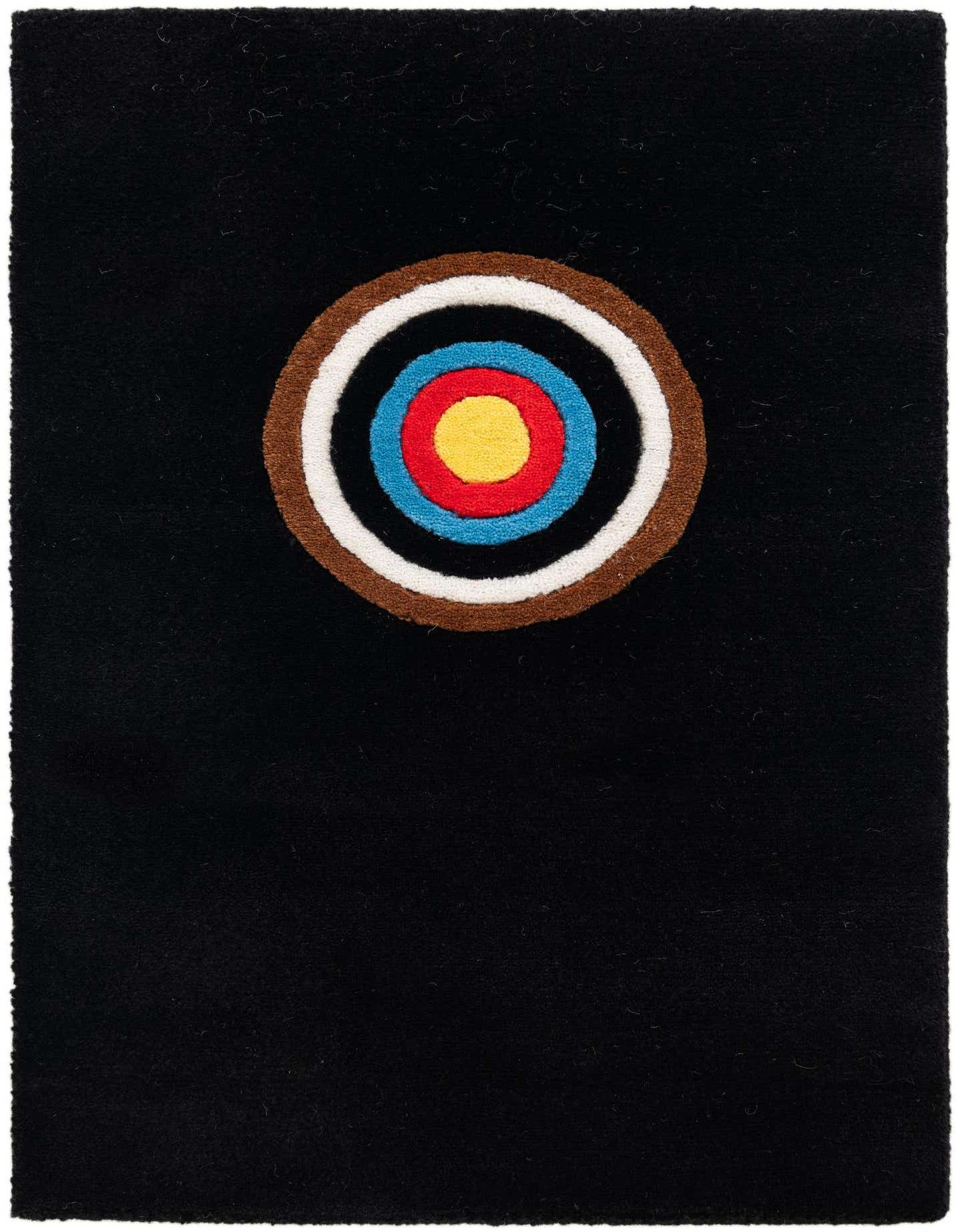 A 1x2 rectangular black rug featuring a large, colorful target-like circle with concentric rings of brown, white, blue, red, and yellow.