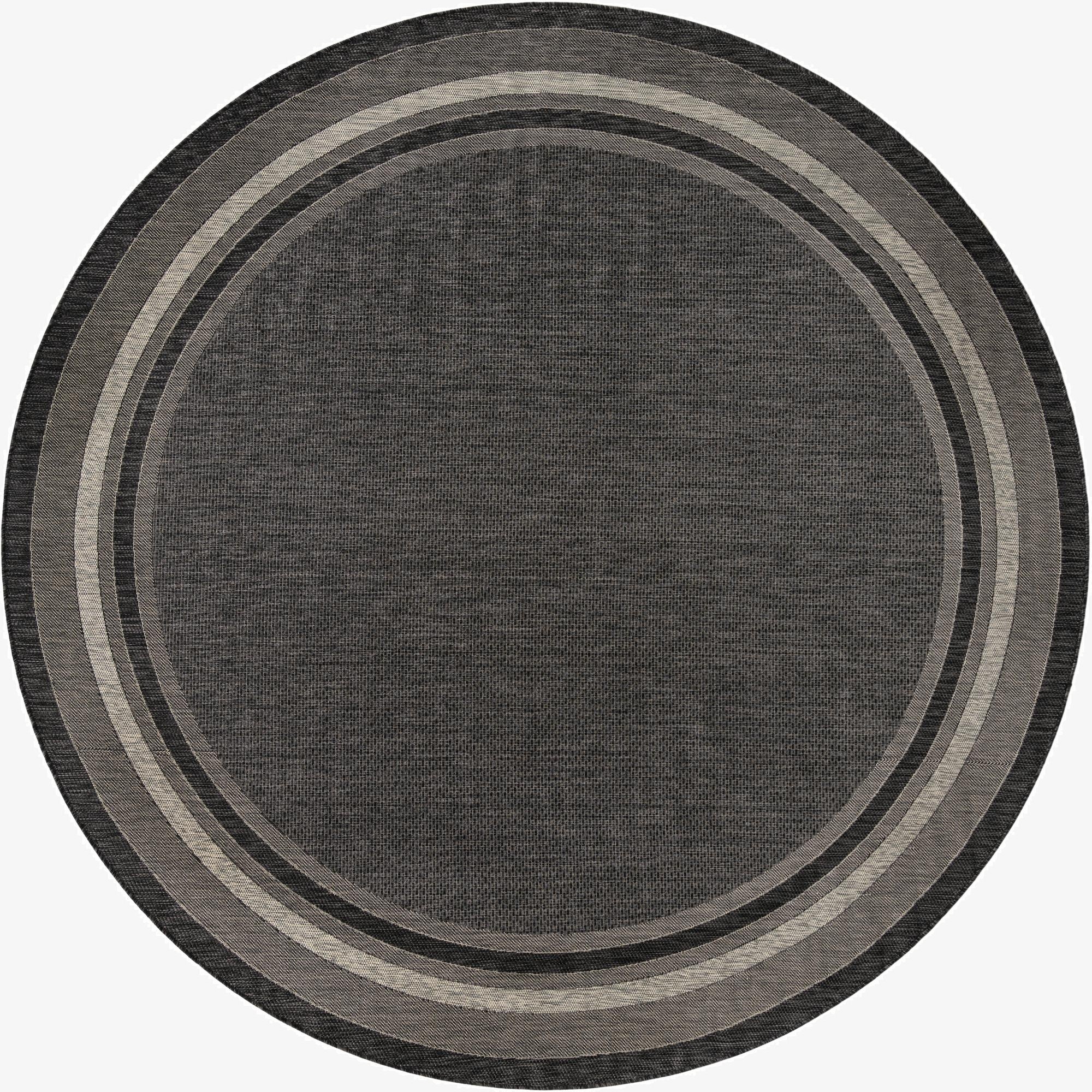 A large 13' round black indoor/outdoor rug with concentric light and dark gray borders, showcasing its flatweave texture.