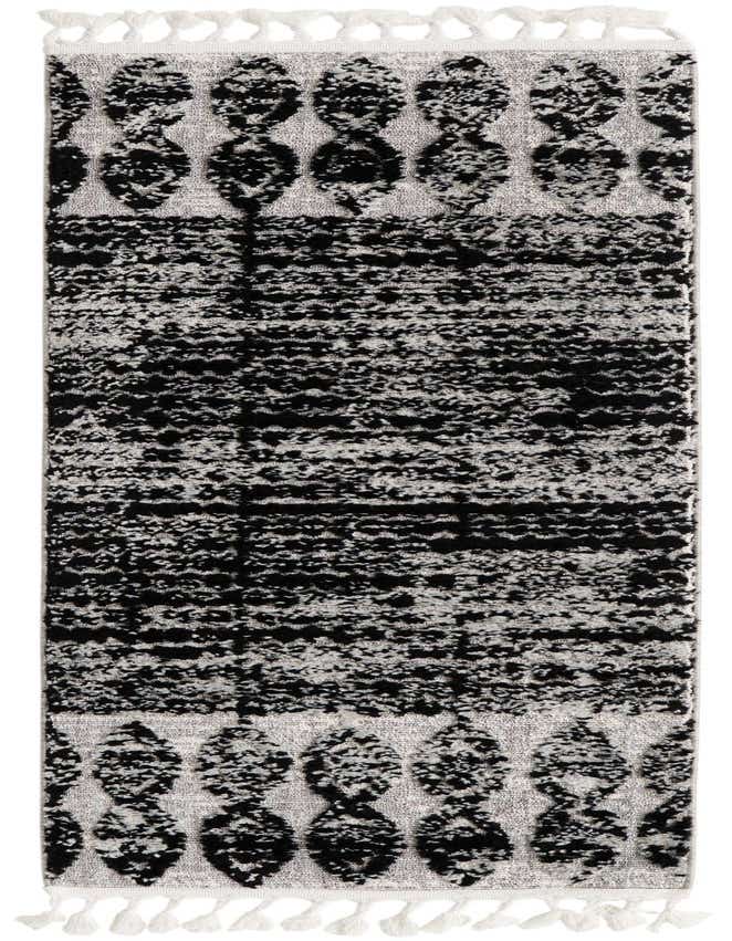 A 6 ft runner rug featuring a black tribal and abstract pattern on a light gray background, with white tassels.