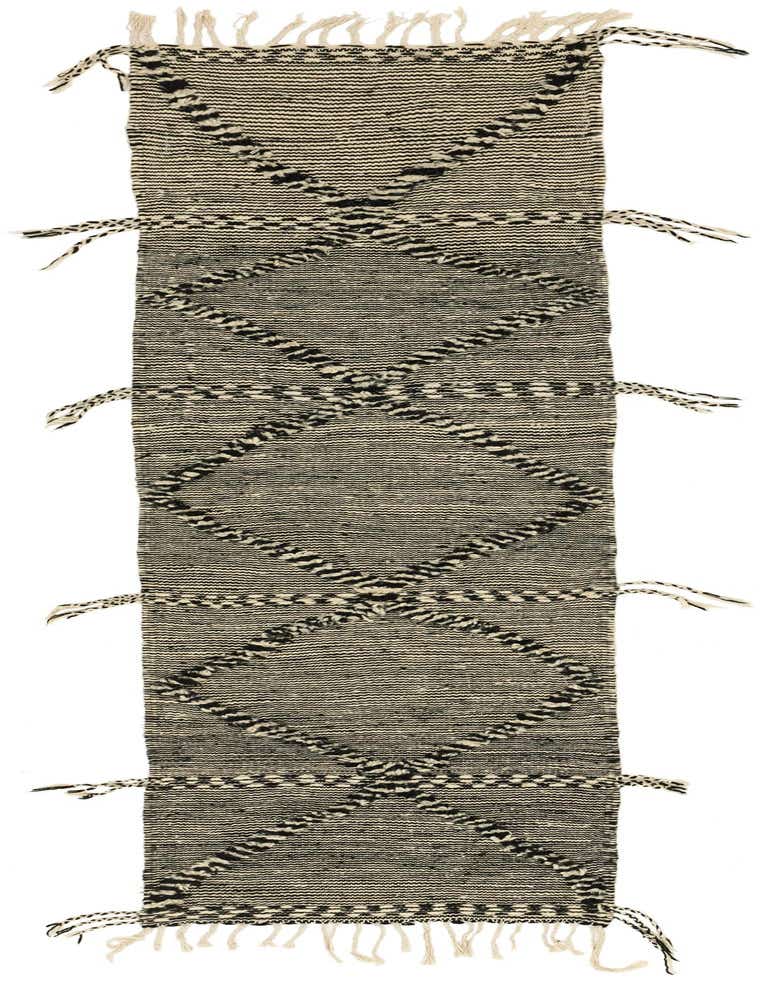 A black and off-white 10 ft runner rug with a tribal diamond pattern and shag pile, ideal for a hallway.