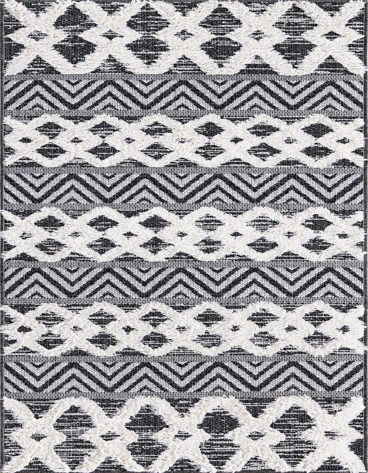 A close-up of a black and white tribal runner rug featuring textured diamond and chevron patterns, ideal for a hallway.