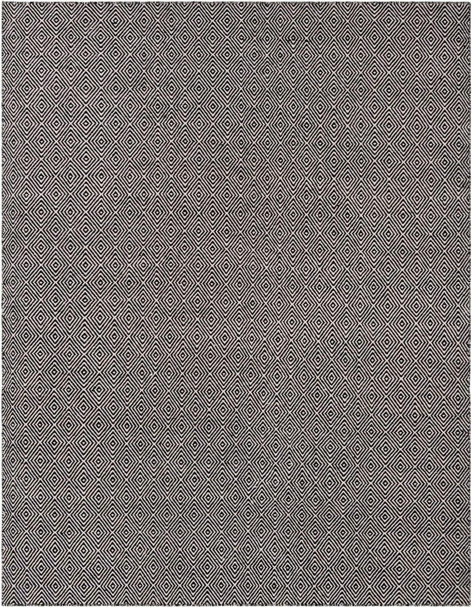A close-up of a square black and white flatweave rug featuring a repeating modern trellis pattern of concentric diamonds.