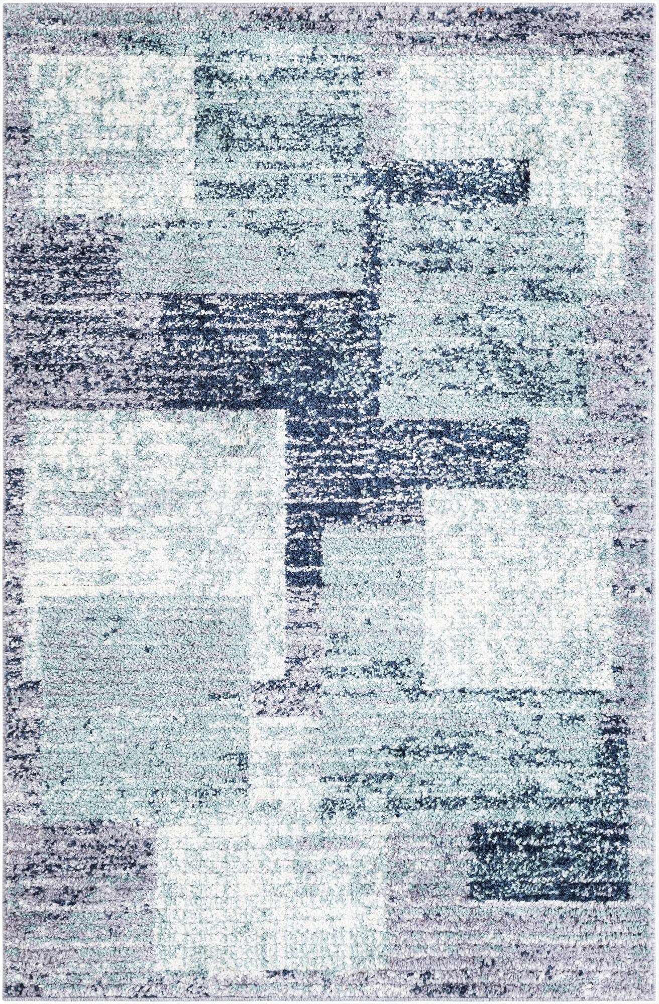 A 4x6 rectangular shag rug featuring an abstract pattern with blocks of light blue, dark blue, and gray.