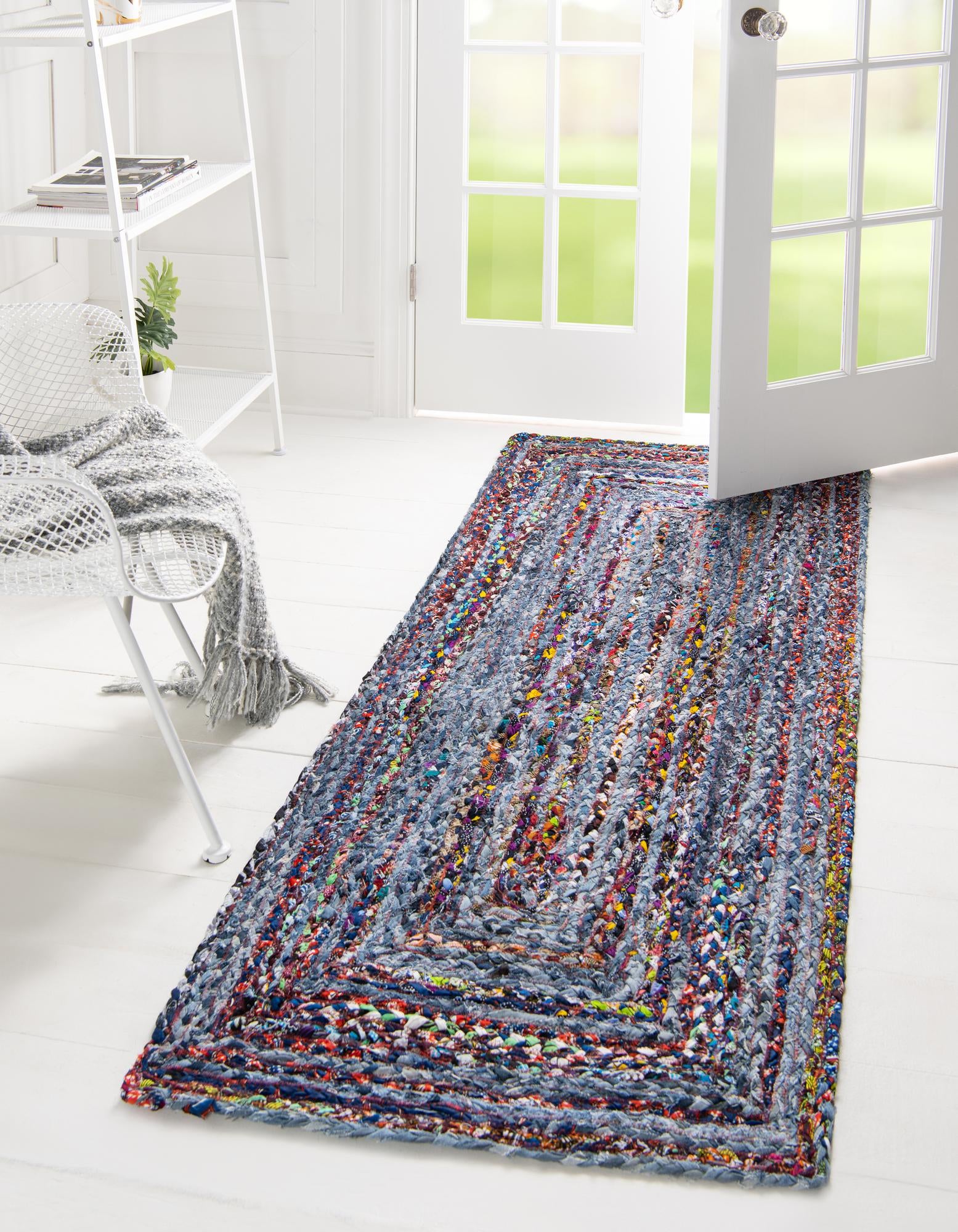 A 6 ft runner rug featuring braided denim cotton in shades of blue with colorful multi-patterned stripes, ideal for a hallway.