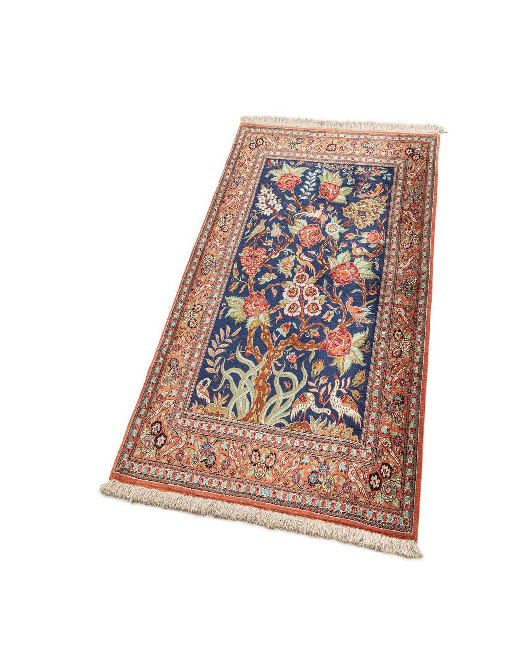 A 4x6 rectangular Ghom Silk rug with a deep blue field featuring a tree-of-life design with red flowers and birds, bordered by intricate coral and blue patterns.