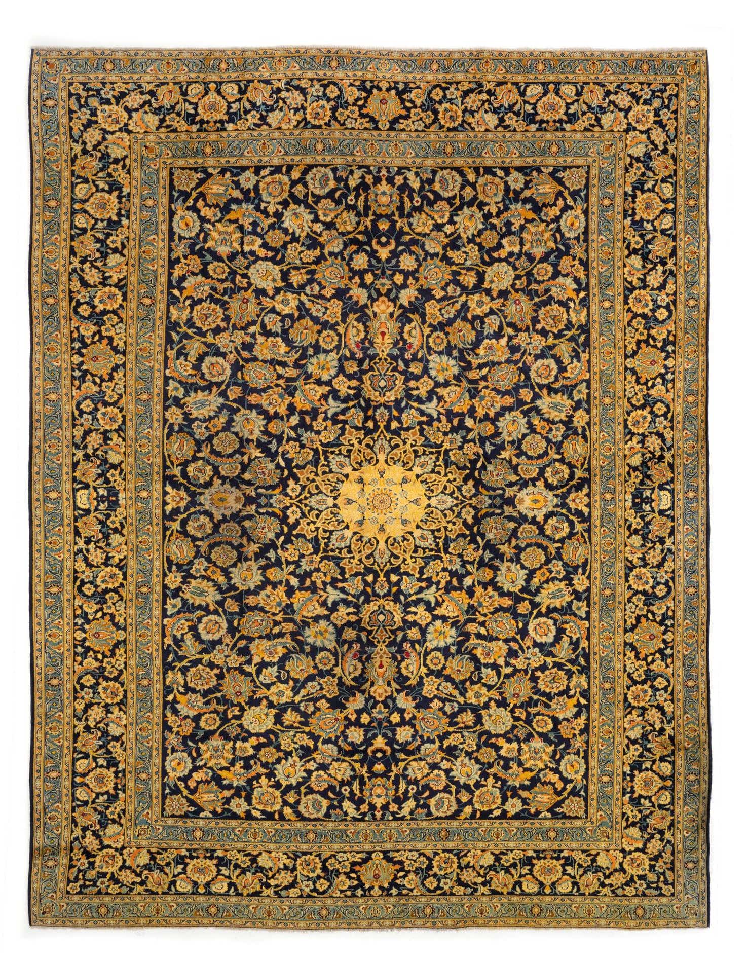 A large 10x13 rectangular Persian rug with a dark blue field and intricate gold and light blue floral patterns, featuring a prominent central medallion.