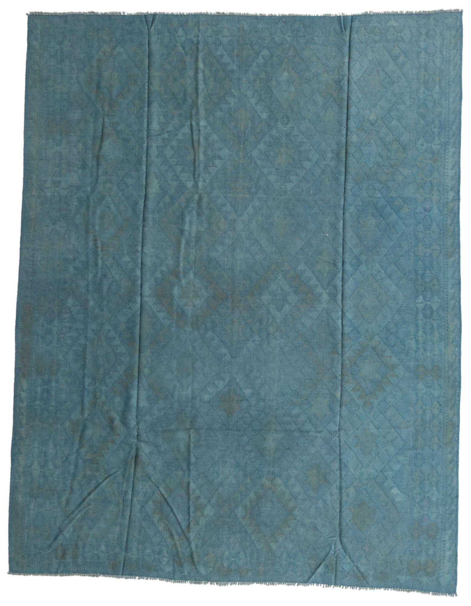 An 8x10 rectangular blue flatweave wool rug featuring a subtle tribal geometric pattern, suitable for a living room.
