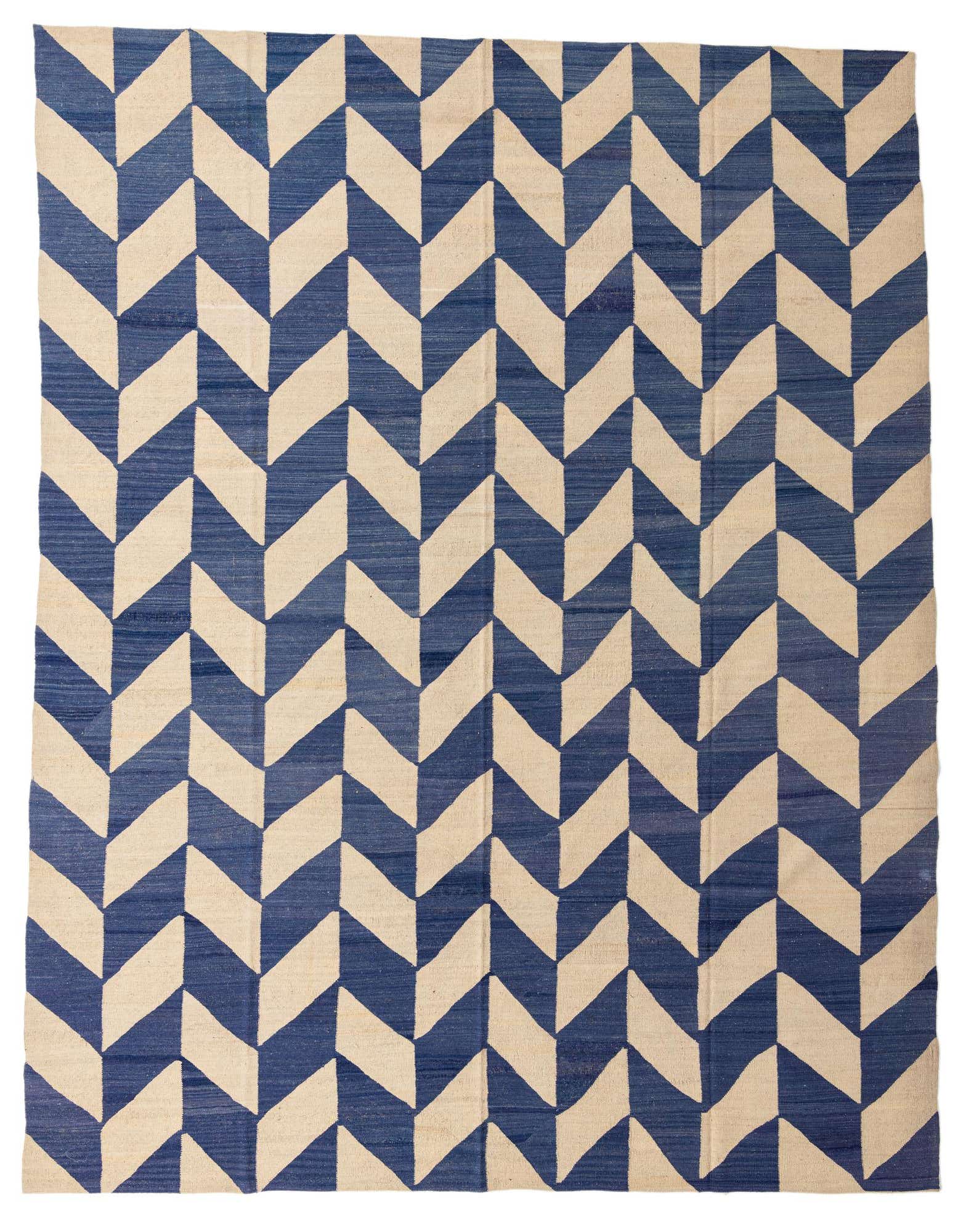 A 10x13 rectangular blue and beige wool flatweave rug with a bold chevron pattern, suitable for a living room.