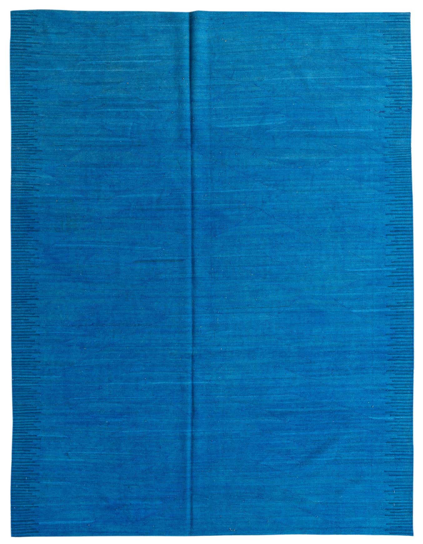 A 6x9 rectangular flatweave rug in a vibrant solid blue color, featuring subtle tribal patterns along the edges.