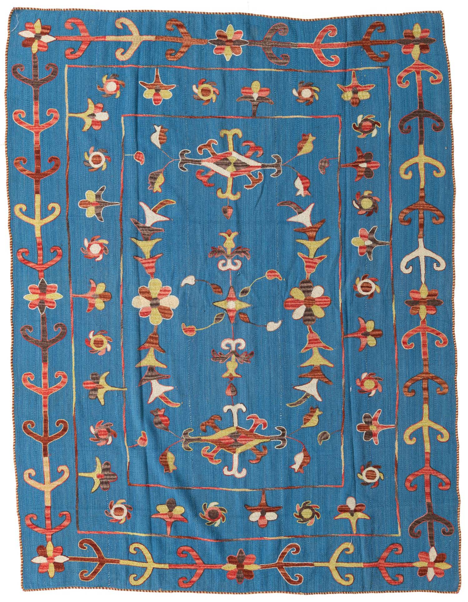 A 5x8 rectangular blue flatweave rug with a colorful tribal Suzani pattern in red, yellow, and brown.