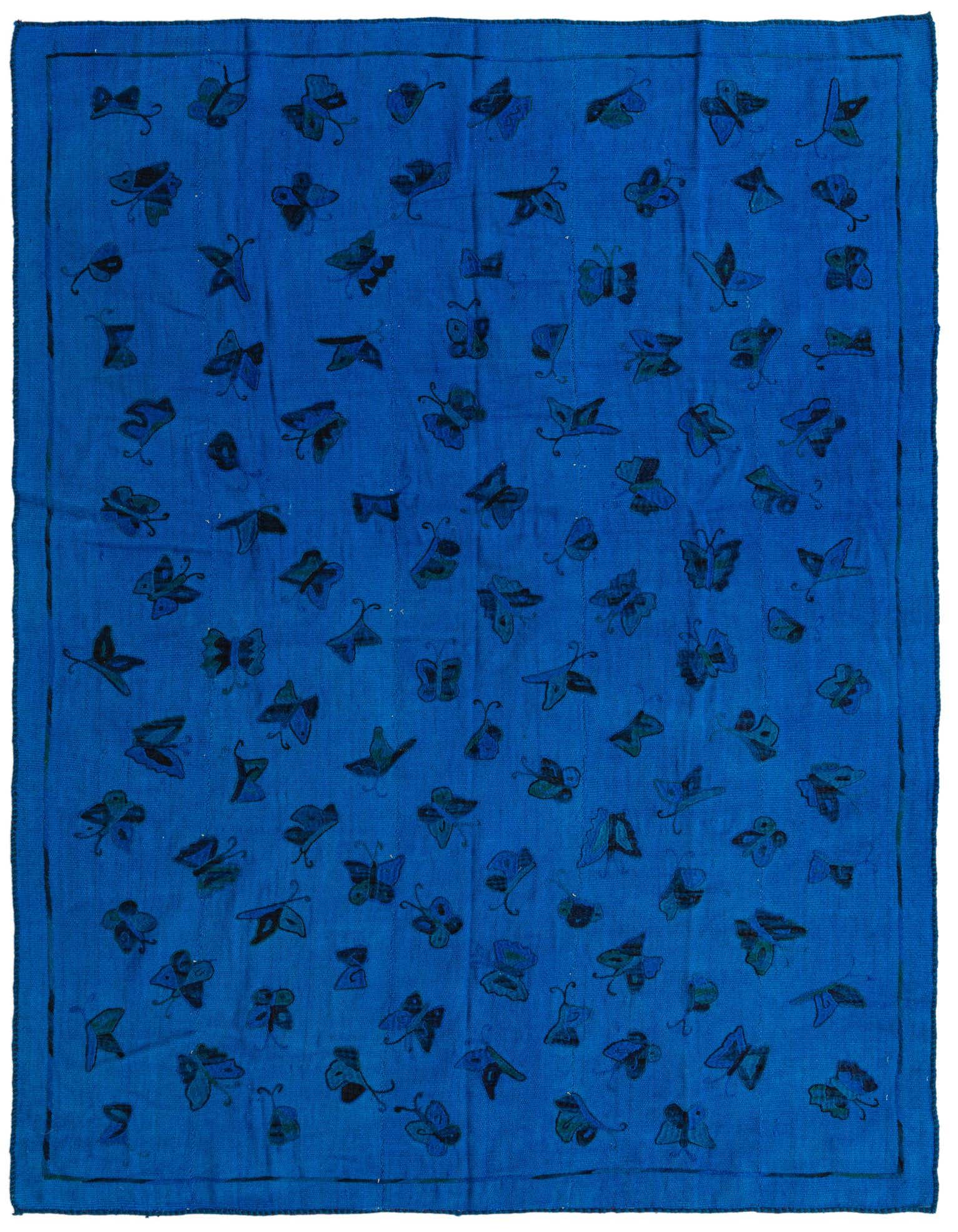 A 6x9 rectangular blue flatweave rug with a repeating pattern of dark blue and teal abstract butterfly motifs.