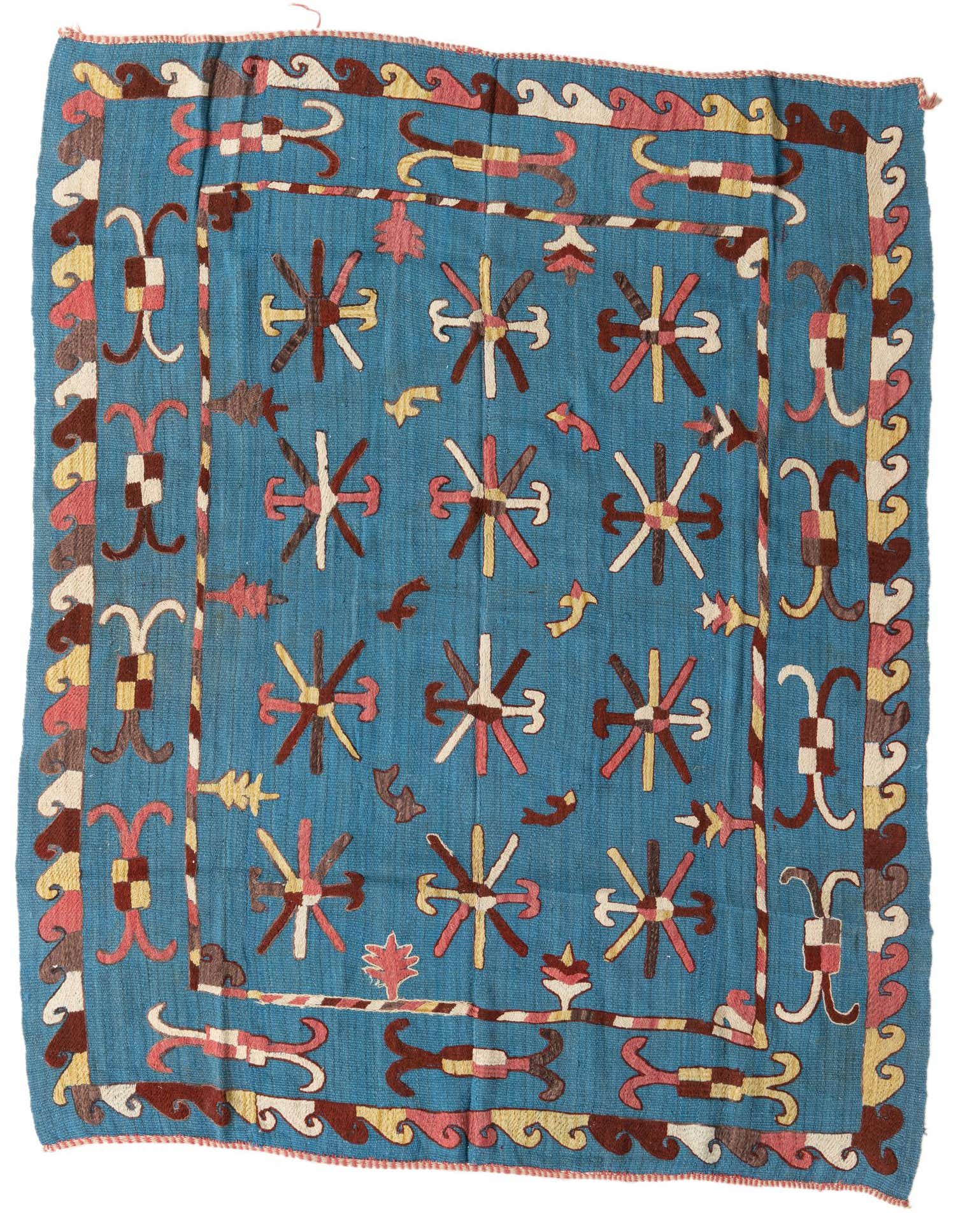 A 5x8 rectangular blue Kilim Suzani rug with a tribal pattern of starbursts and geometric borders in brown, pink, and cream.