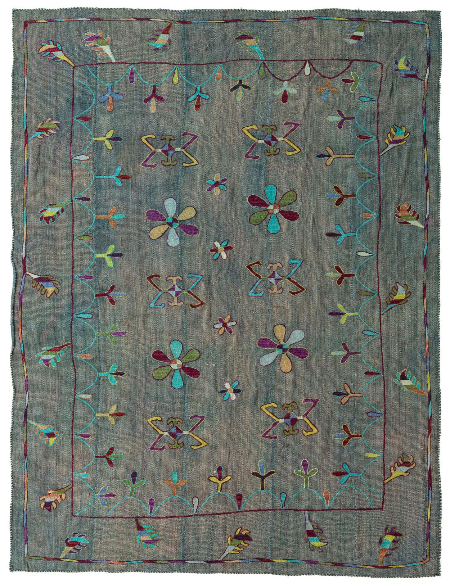 A 6x9 rectangular blue flatweave rug with a colorful tribal Suzani pattern, featuring floral and geometric motifs.