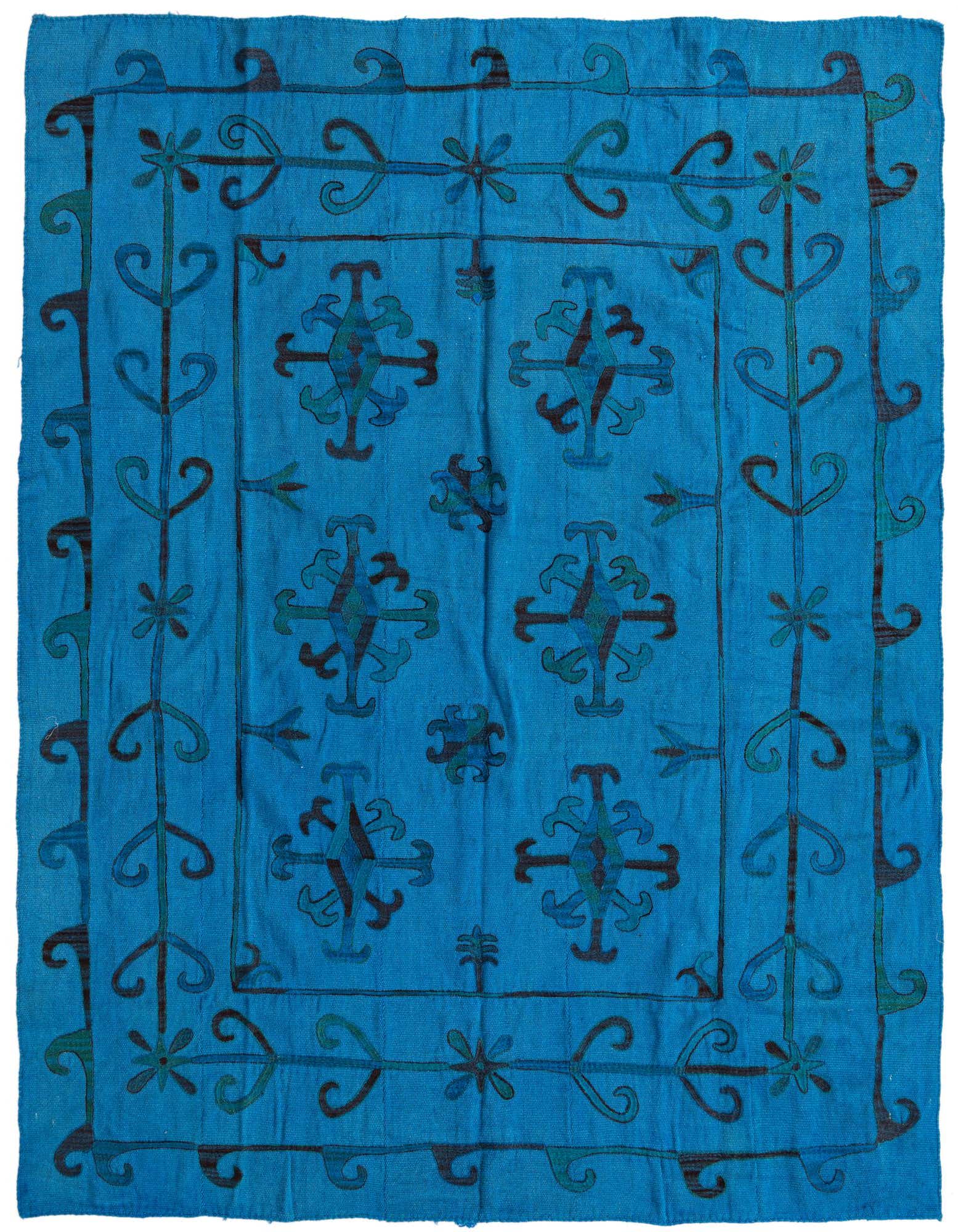 A 6x9 rectangular blue flatweave rug with a tribal Suzani pattern and abstract oriental motifs.