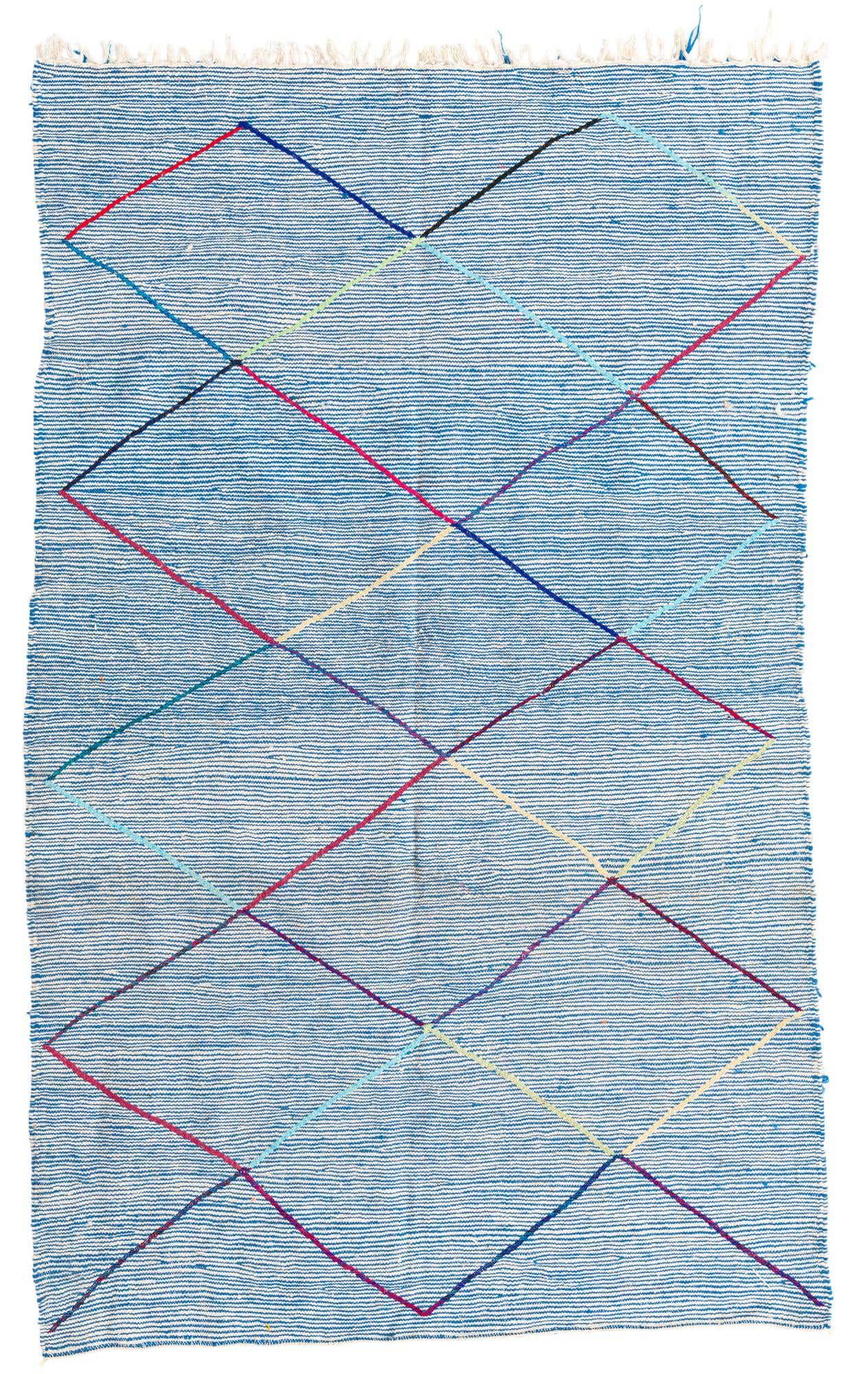 A 5x8 rectangular blue shag rug with a modern tribal diamond pattern in various bright colors, suitable for a living room.