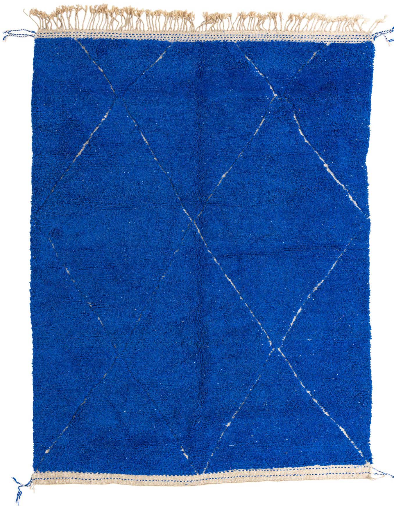 A 7x10 rectangular blue shag rug with a white tribal diamond pattern and fringe, suitable for a living room.