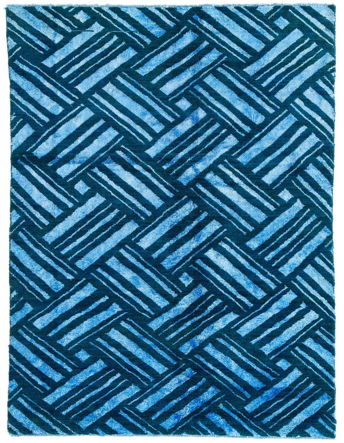 A 5x8 rectangular blue shag rug with a modern tribal pattern of interlocking light and dark blue stripes.
