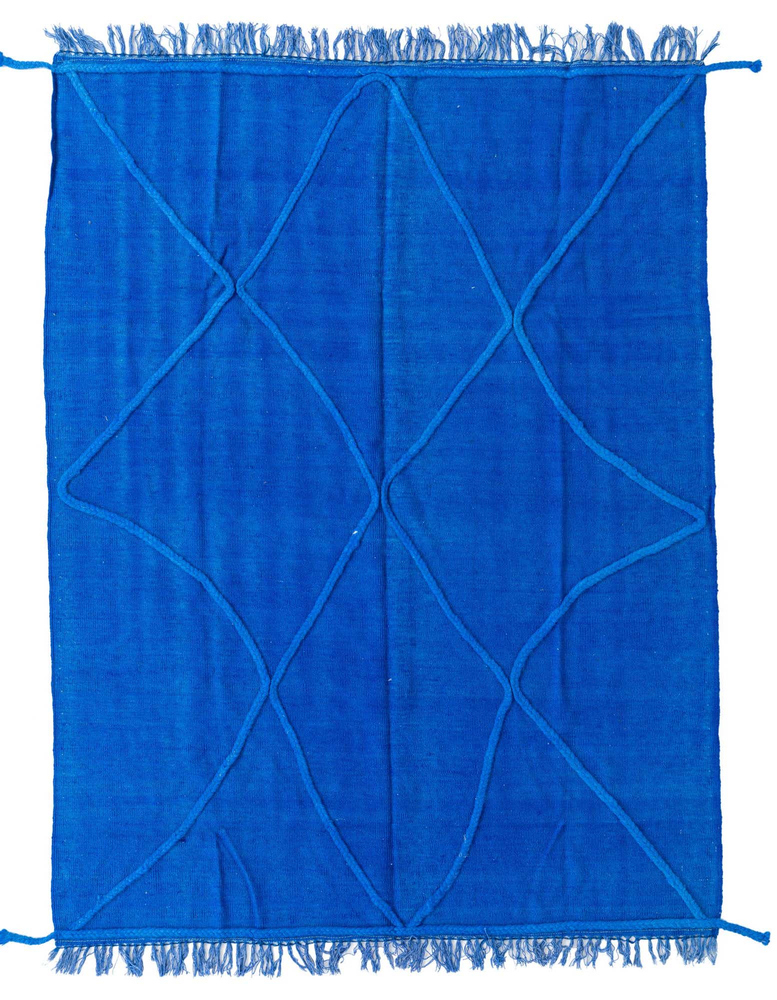 A vibrant 5x8 rectangular blue wool shag rug with a raised geometric diamond pattern and fringed edges.