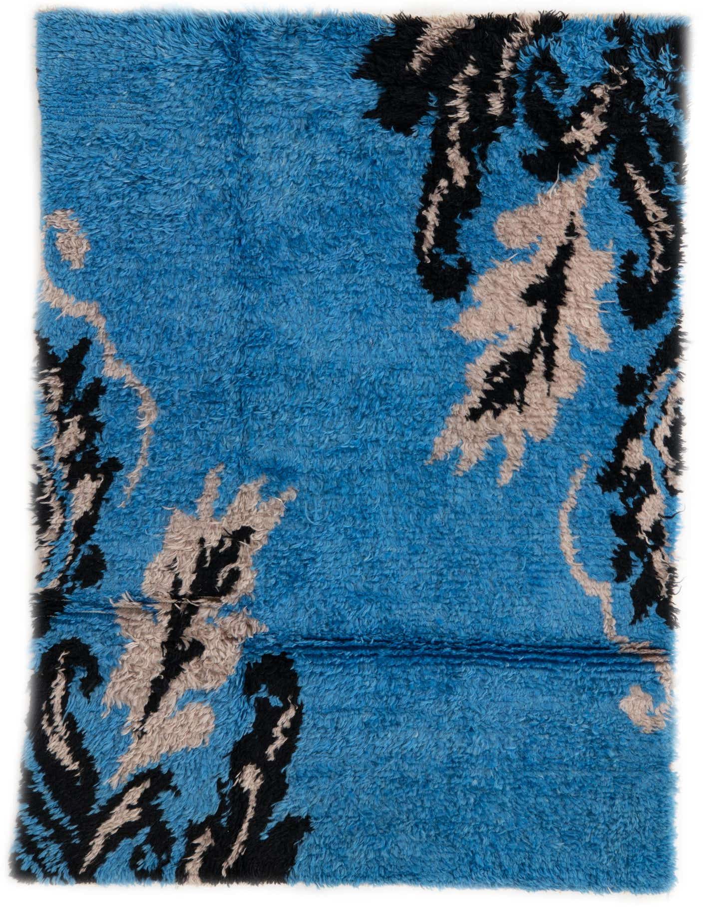 A 4x6 rectangular blue shag rug with a modern tribal pattern in black and light brown, suitable for a living room.