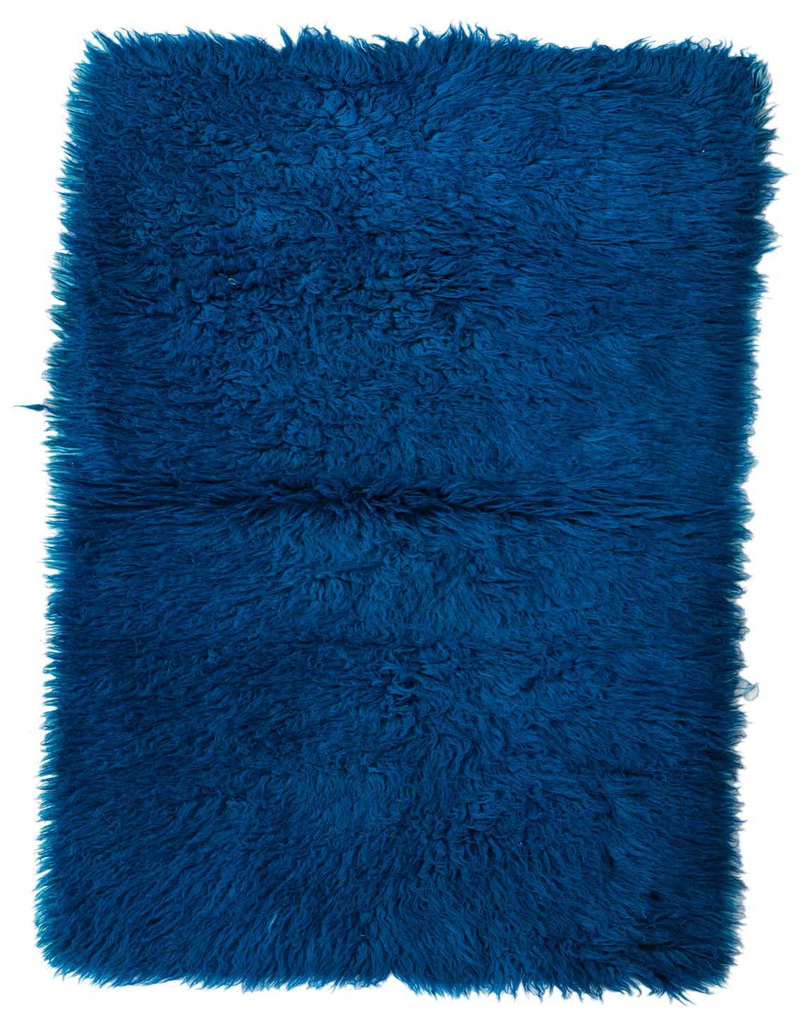 A rectangular 3x5 blue shag rug, handmade from wool, featuring a plush, solid texture.