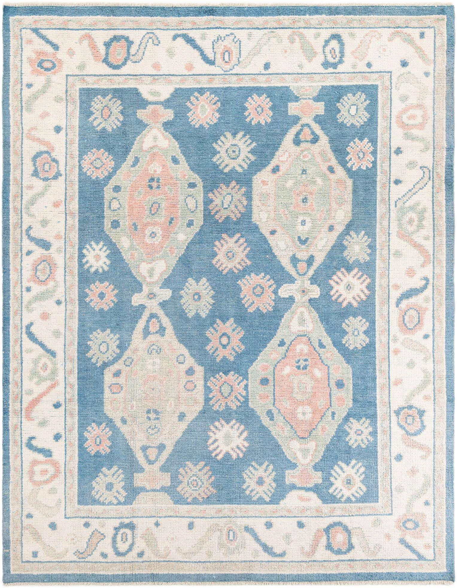 A rectangular 8x10 blue Moroccan shag rug with tribal medallion patterns in cream, pink, and light green.
