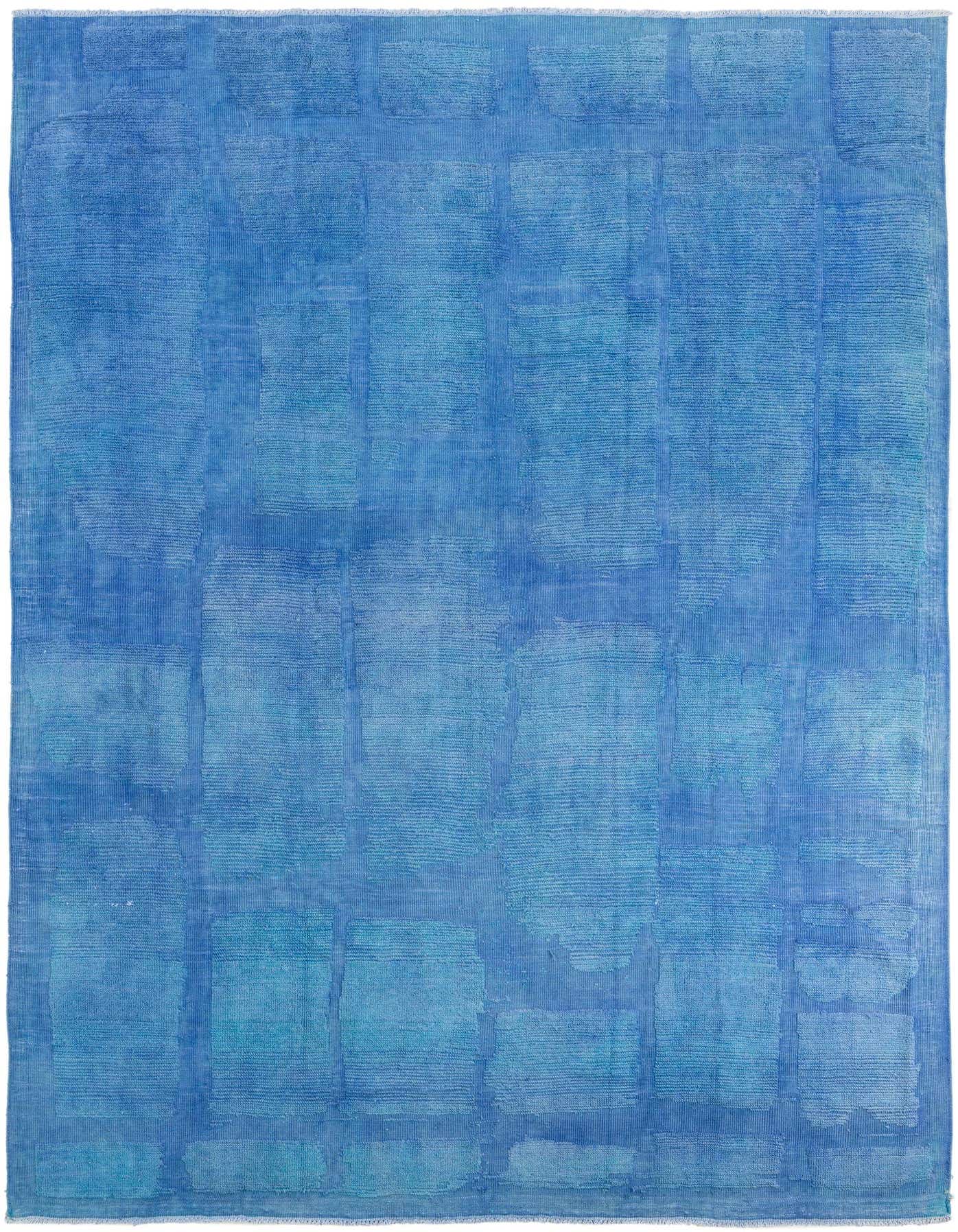 An 8x12 rectangular blue wool shag rug featuring an abstract tribal pattern with varying shades of blue.