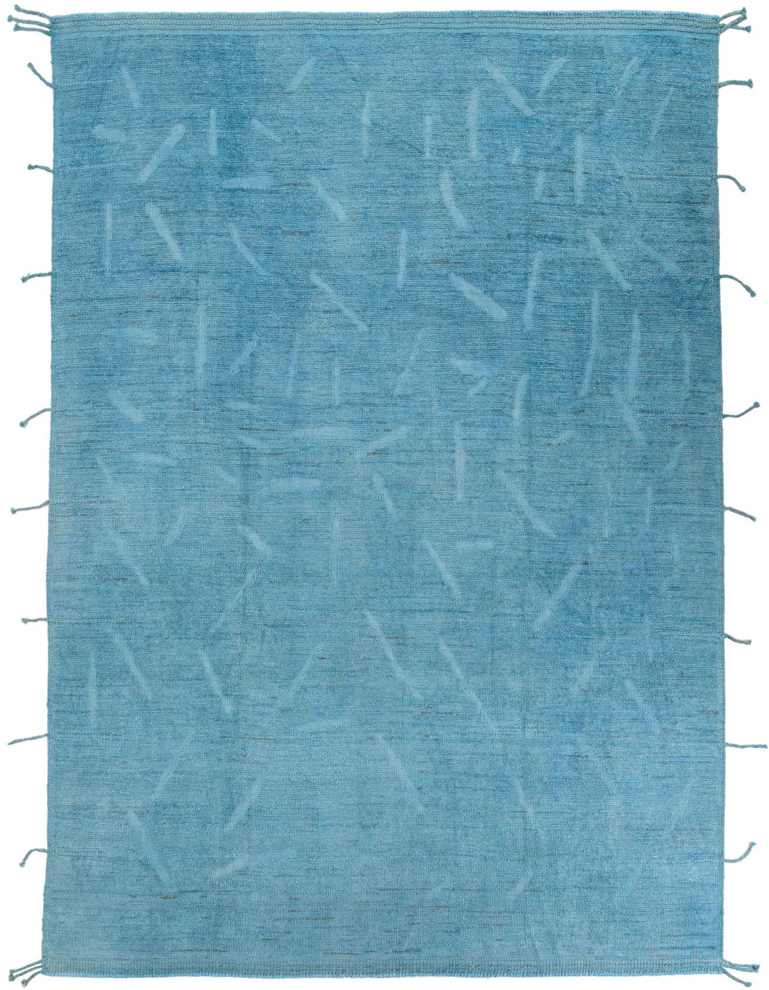 A 9x12 rectangular blue shag rug with a subtle abstract tribal pattern and knotted fringe on a white background.
