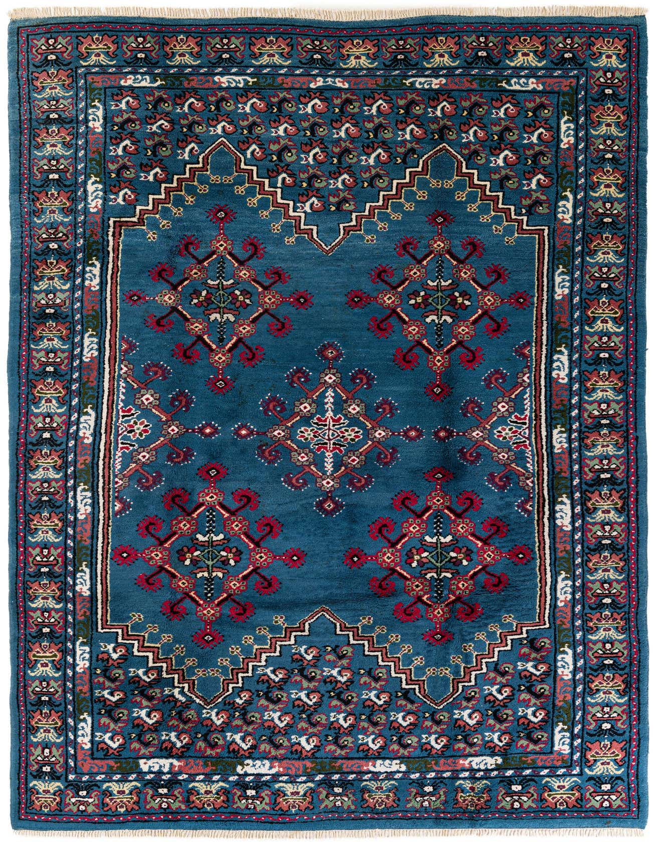A 7x10 rectangular blue Moroccan wool rug with traditional tribal patterns in red, black, and white.